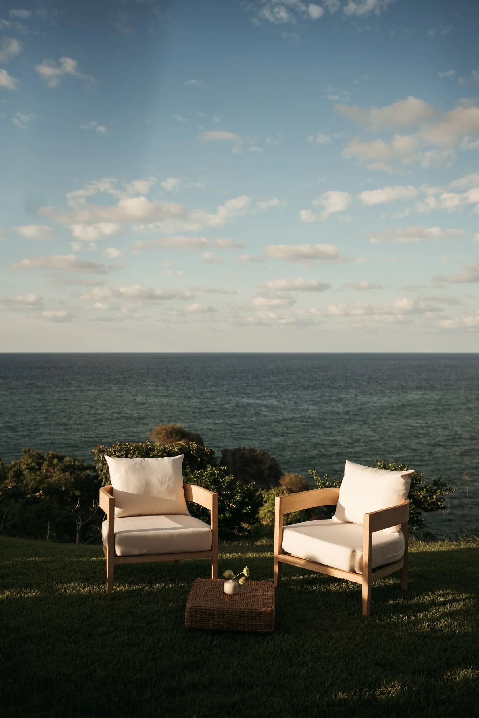 Ceremony lounge seating on the lawn above the Pacific in Sayulita, a single stem on the side table