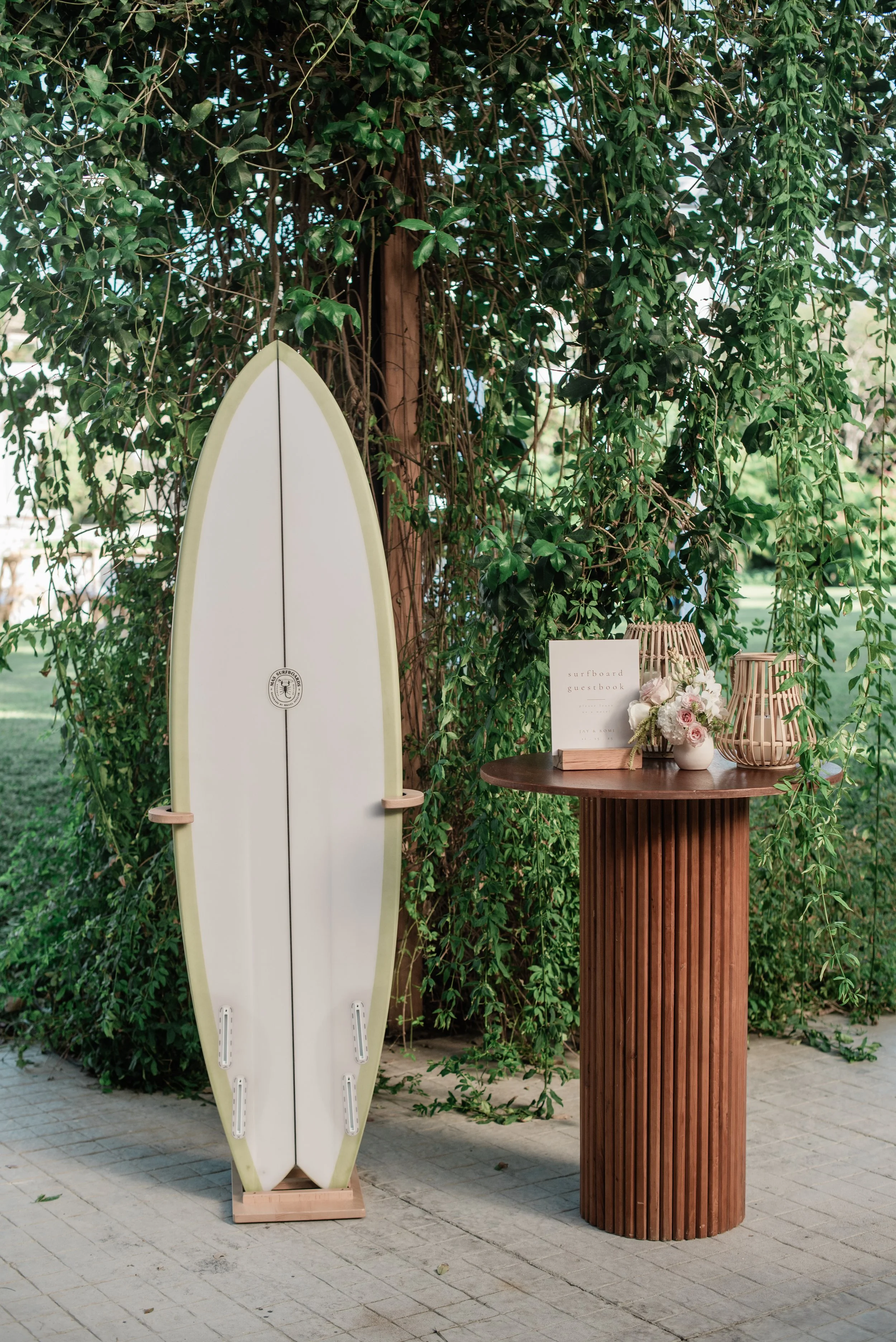 Surfboard guestbook with a blush rose arrangement at W Punta de Mita