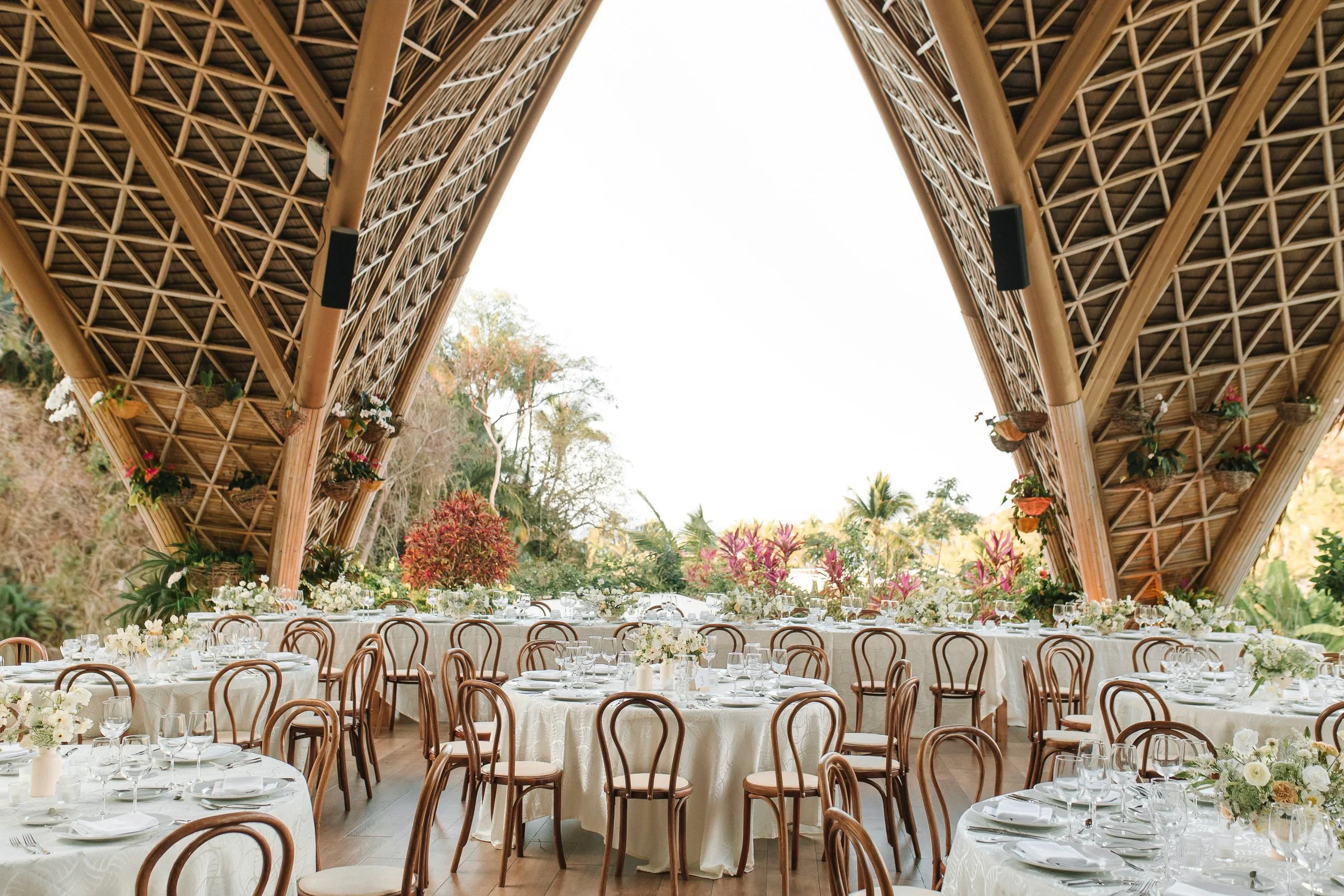 Round reception tables and white florals inside The Forum pavilion at Garza Blanca