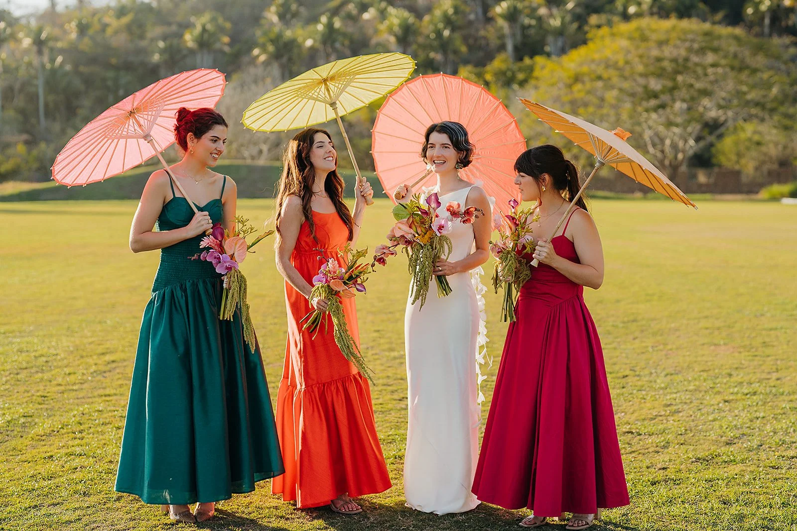 Bridesmaids with parasols and tropical bouquets at Tierra Tropical Polo Club