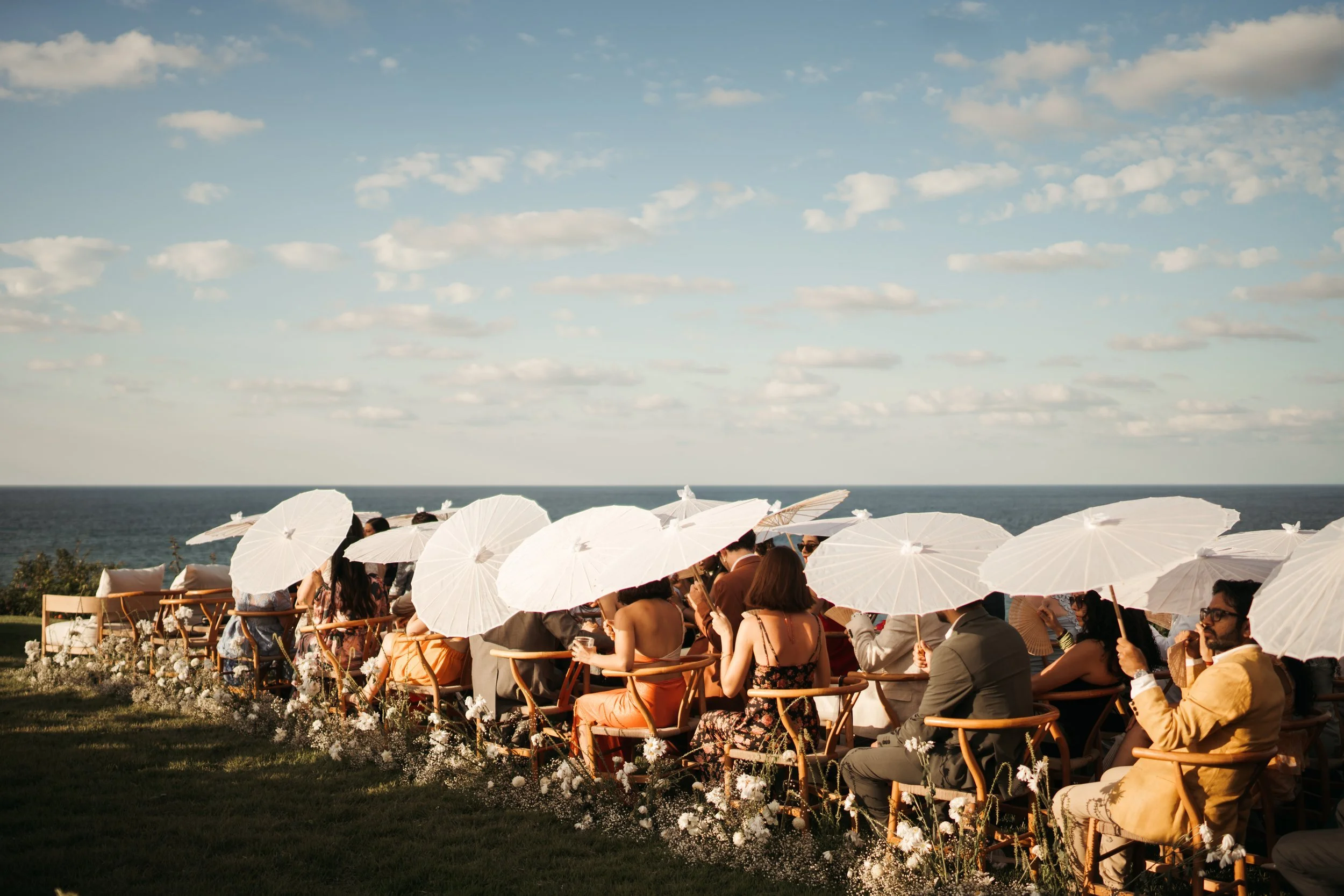 Wide view of an oceanfront wedding ceremony with white parasols on Mexico's Pacific coast