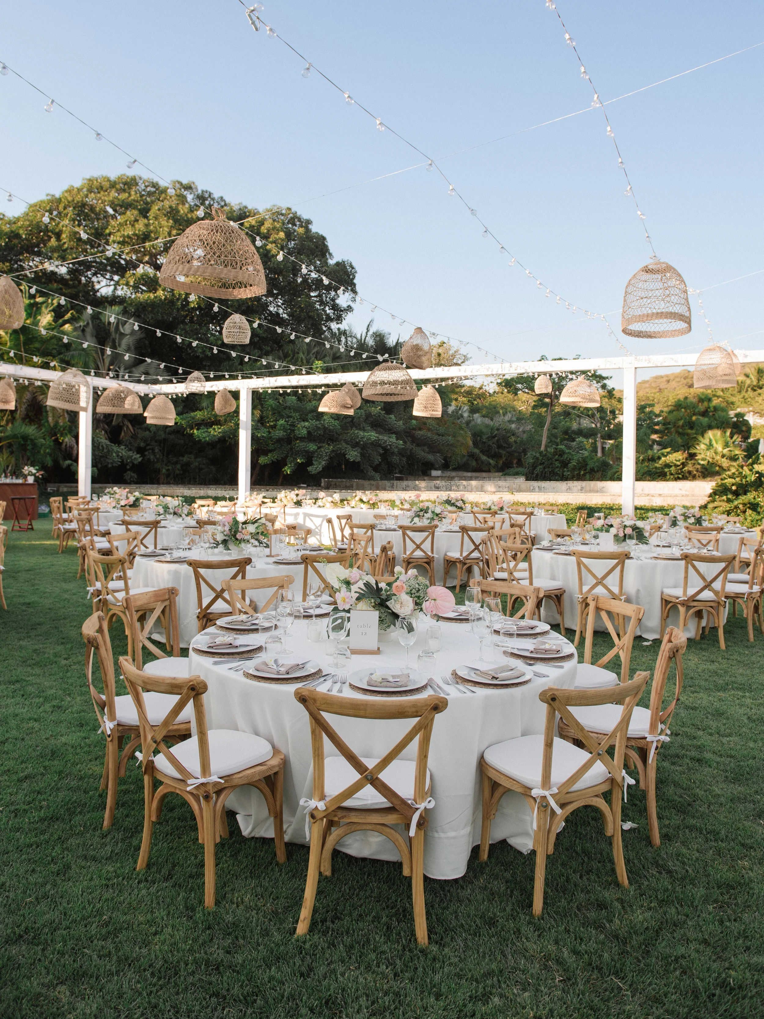 Reception round tables under rattan pendants and string lights at W Punta de Mita