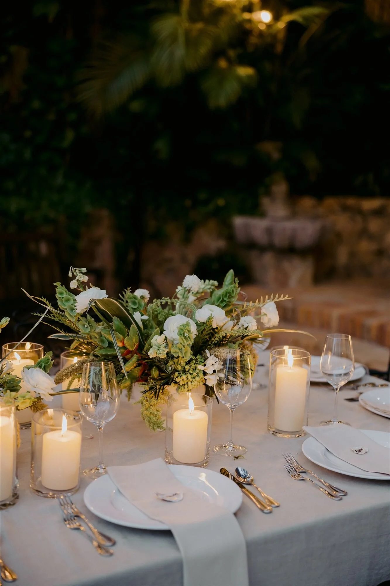 Candlelit reception table at dusk with low florals at Quinta de Los Leones