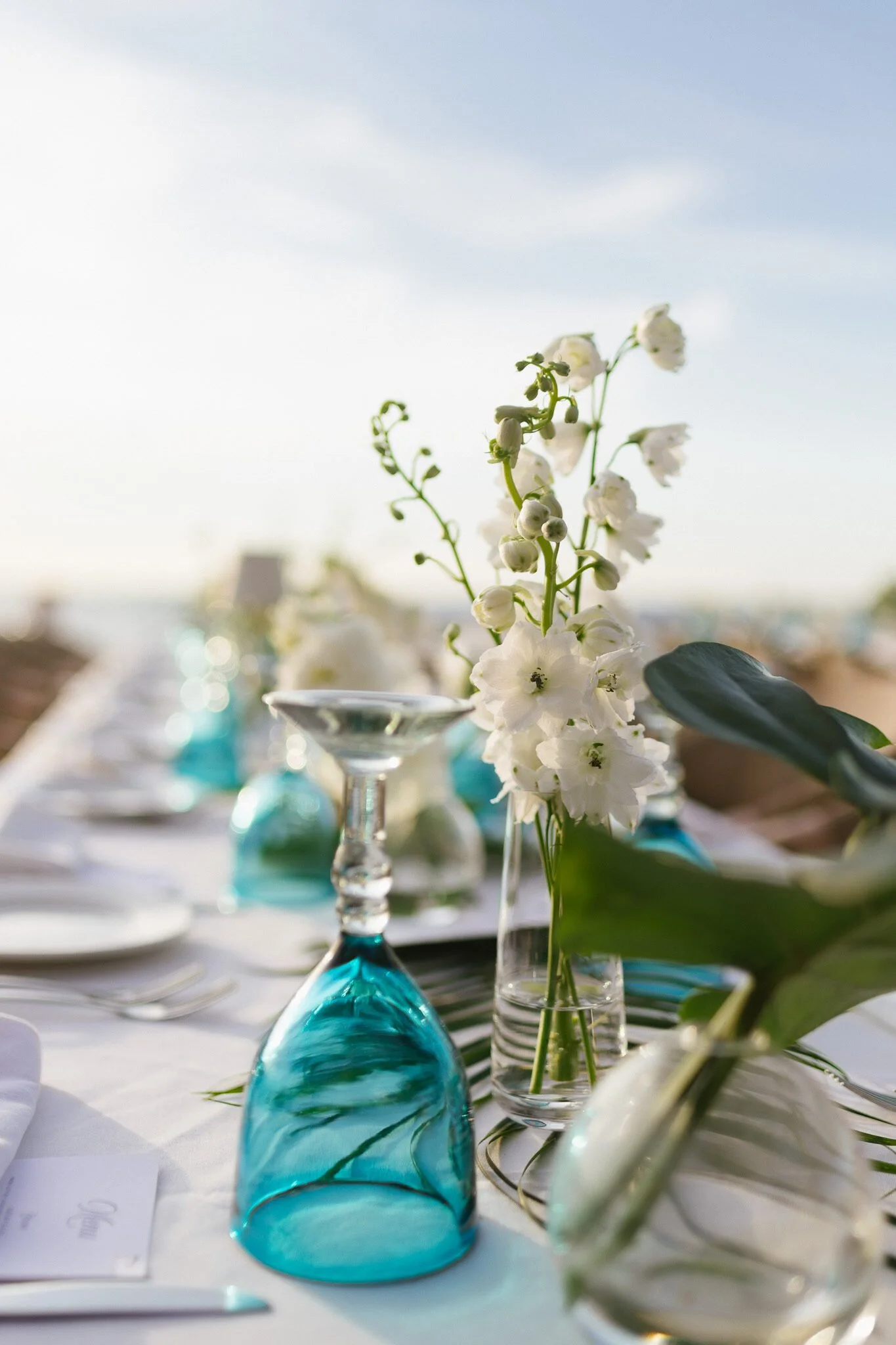 Place setting with turquoise glass and white blooms at El Dorado