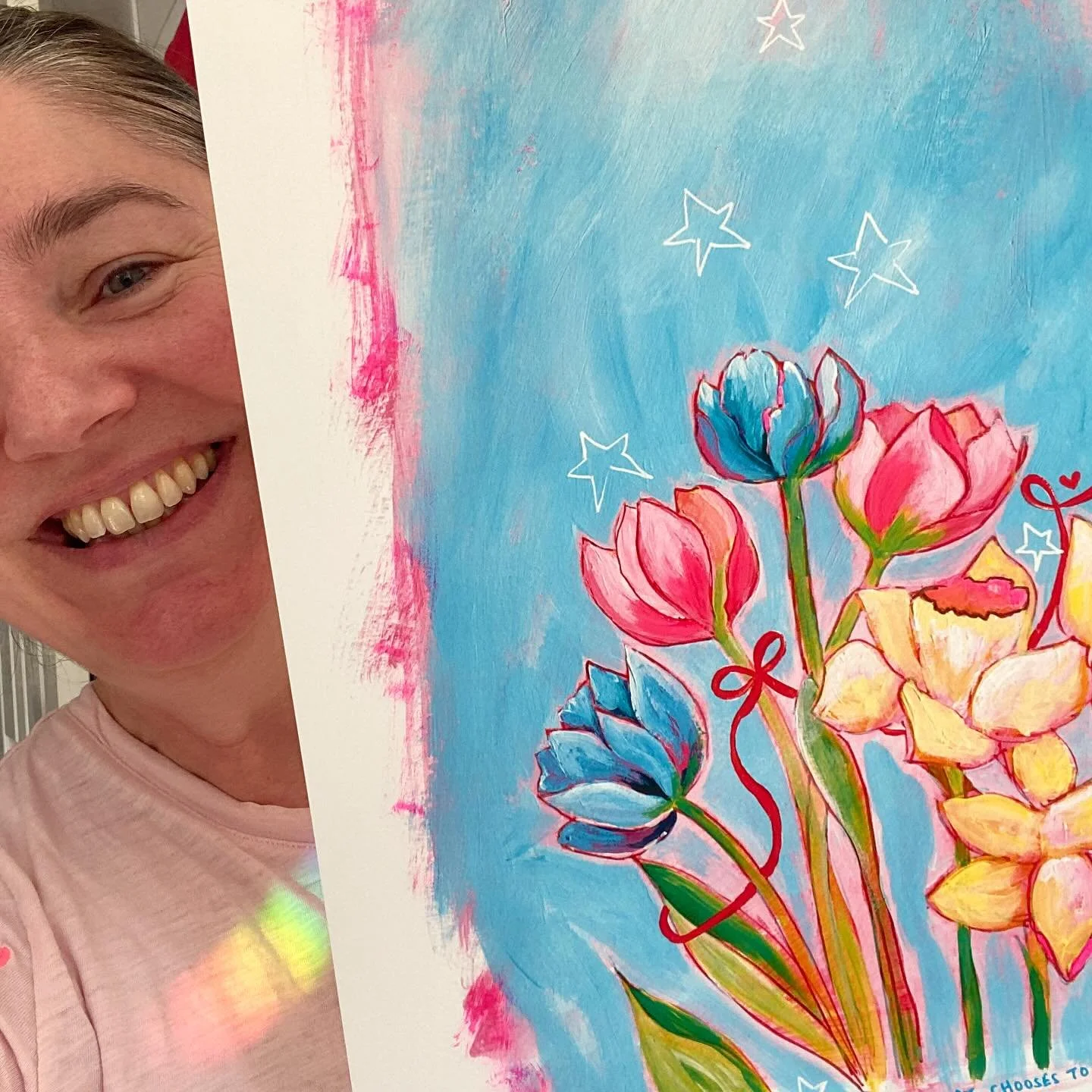 Just me &lsquo;hiding&rsquo; behind my first completed print from my collection called &lsquo;Joy&rsquo;. Can we take a moment to look at the BEAUTIFUL light prism I seem to also be wearing! 🌈⭐️ #nickyluckart #sharealittlelove #joy #joyfulart #daffo