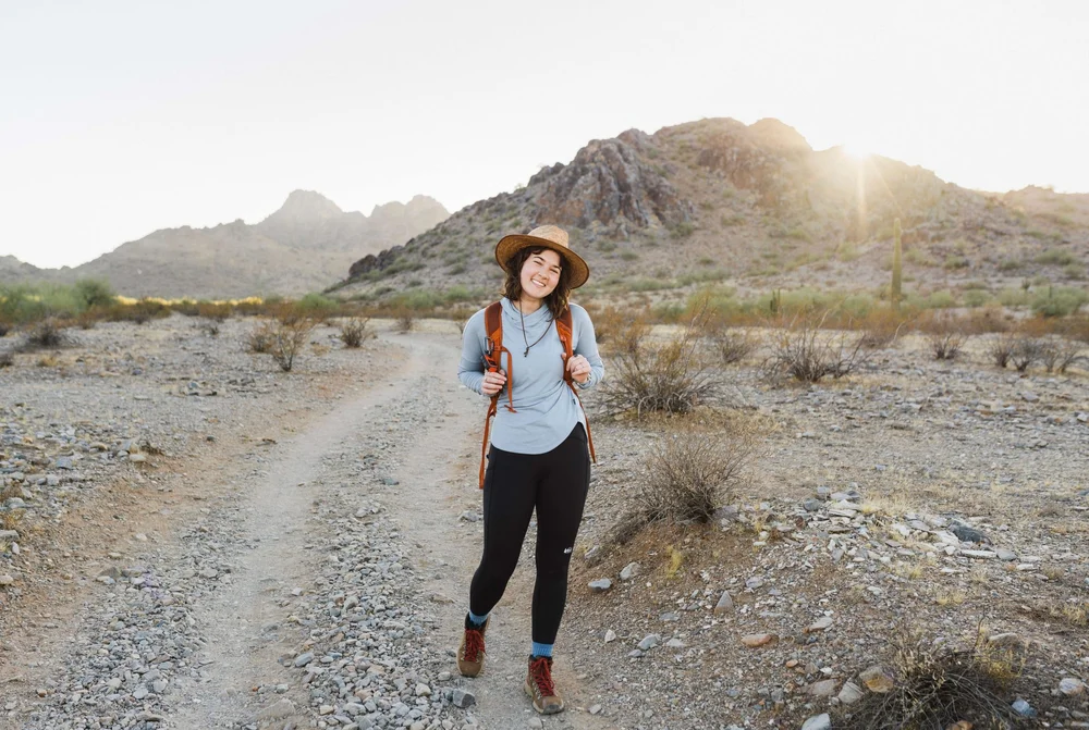woman smiling at camera out on a hike