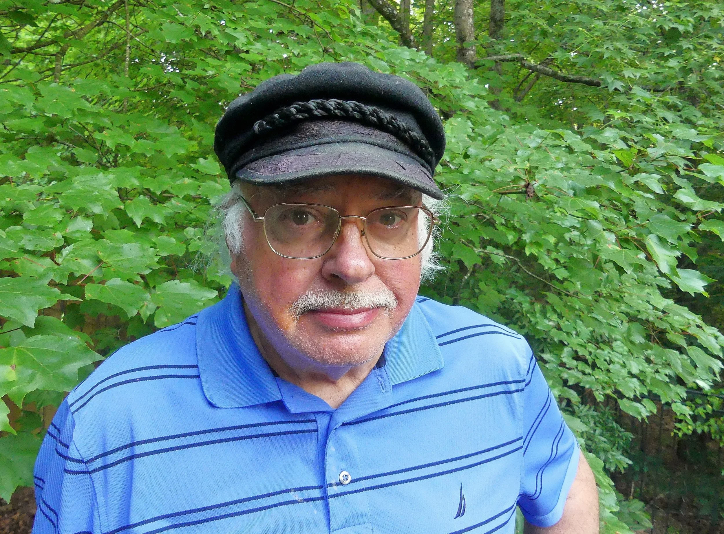 Charles Seabrook standing in front of a green tree.
