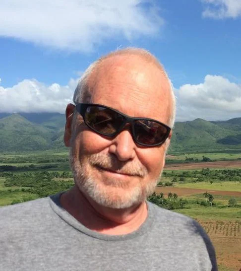 Tommy Hart Jones standing in front of green mountains.