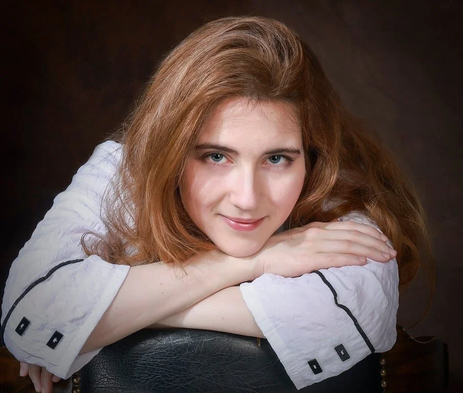 Michelle Izmaylov leaning on a black chair.