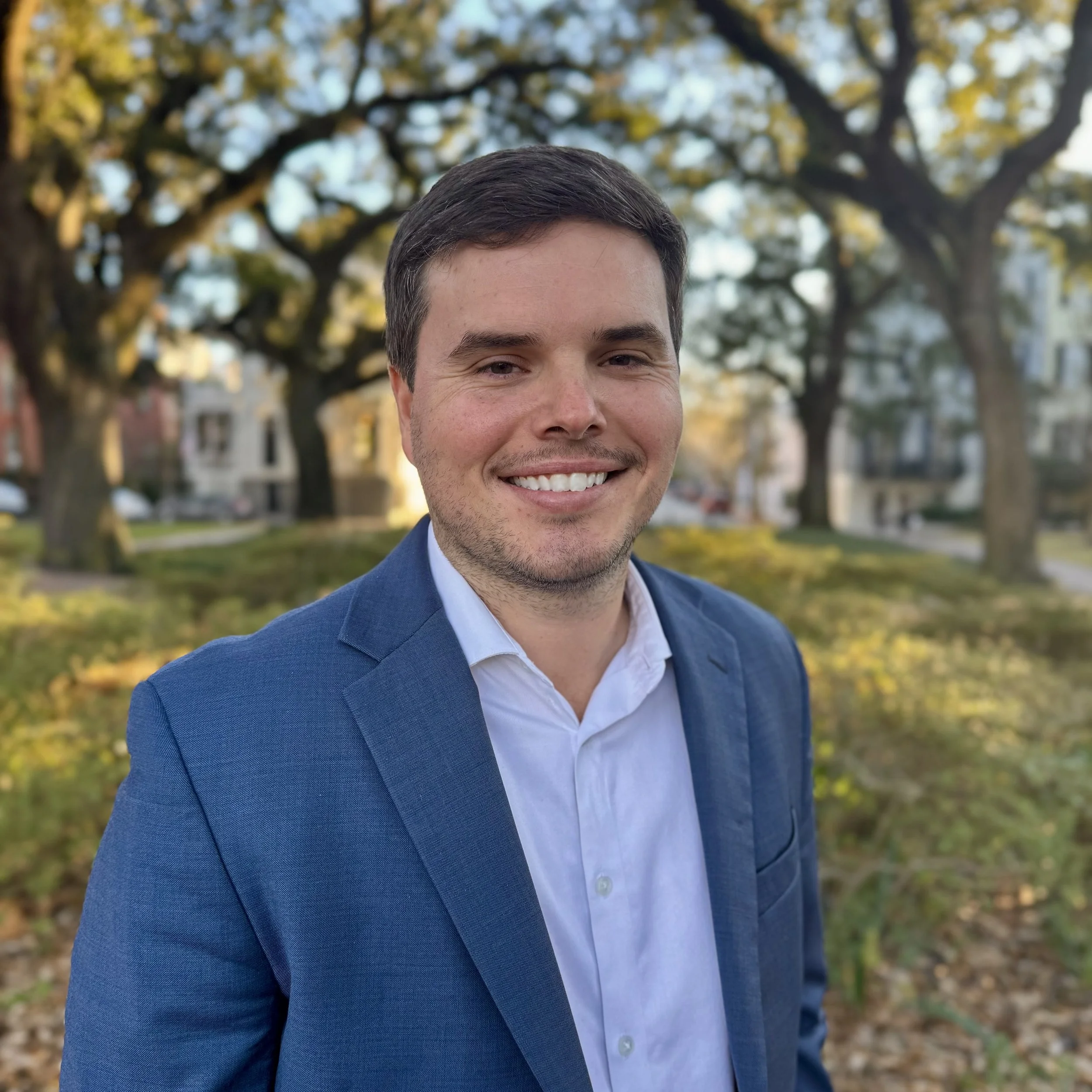 Bennett Parten standing in front of four oak trees.