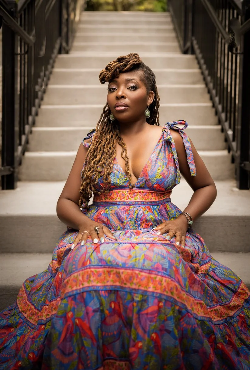 Denene Millner sitting on tan stairs.