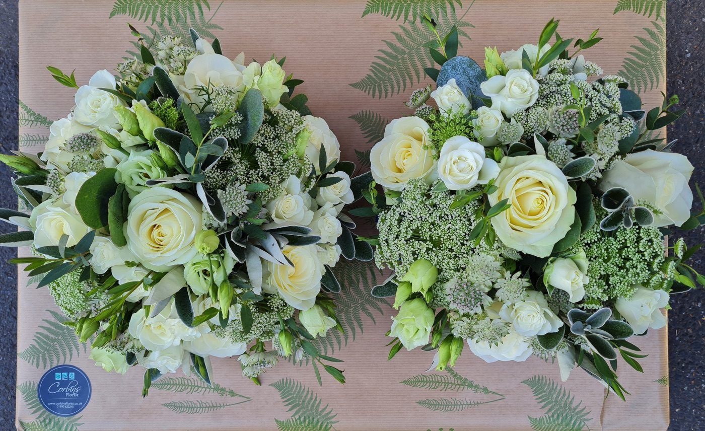A bouquet of flowers including yellow sunflowers, pink roses, white daisies, and purple lavender.