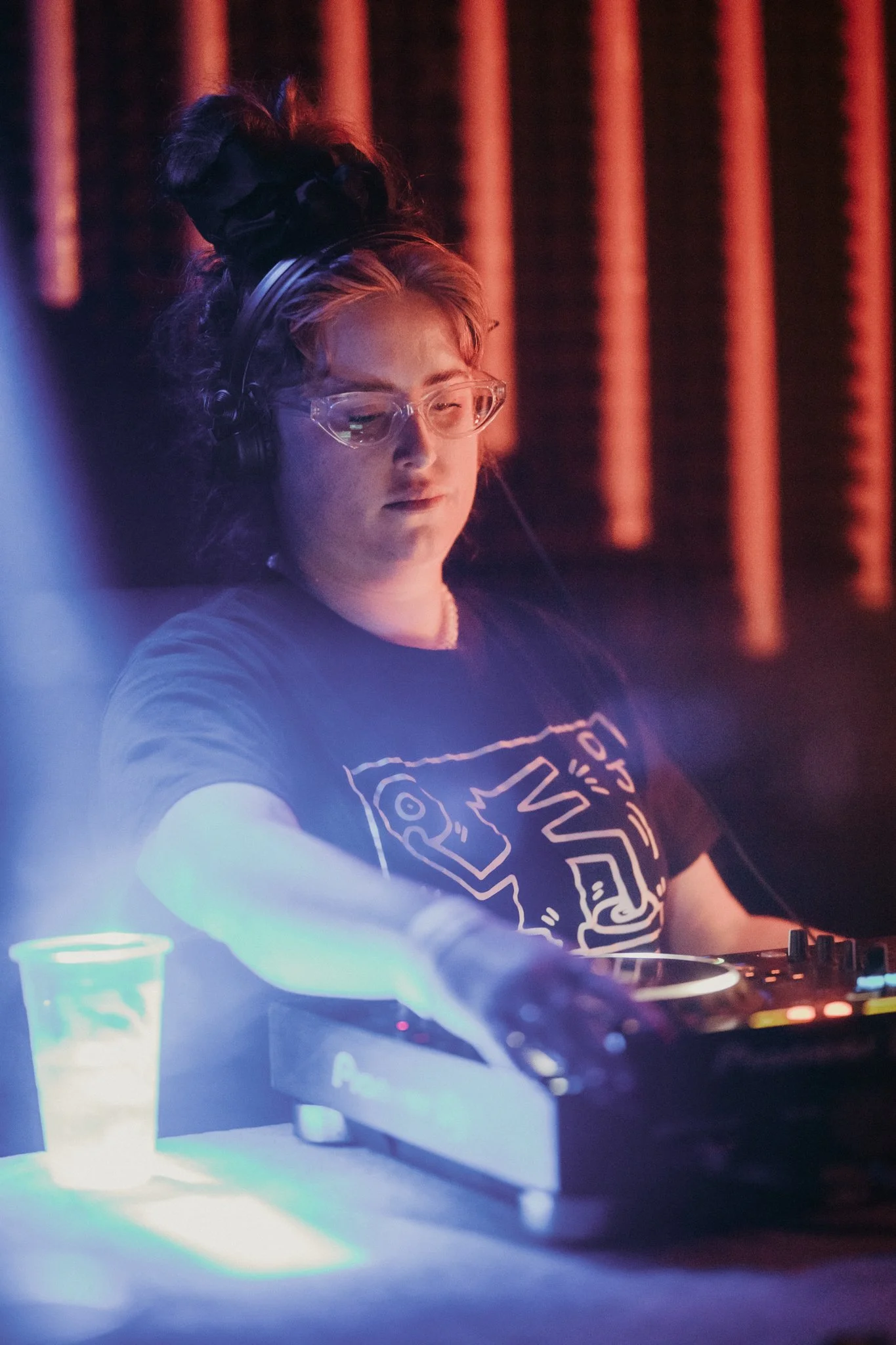 DJ wearing headphones operating a mixer