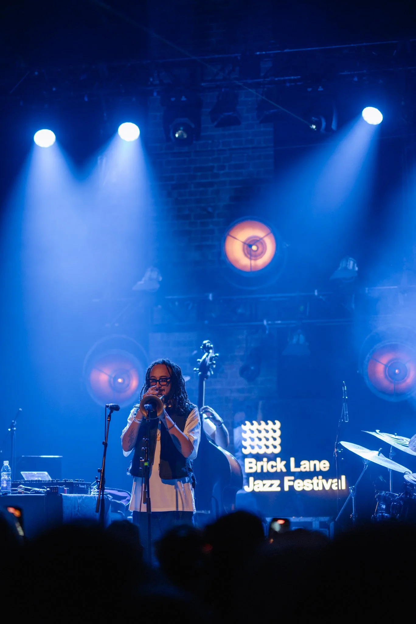 Musician playing trumpet at Brick Lane Jazz Festival, blue stage lighting