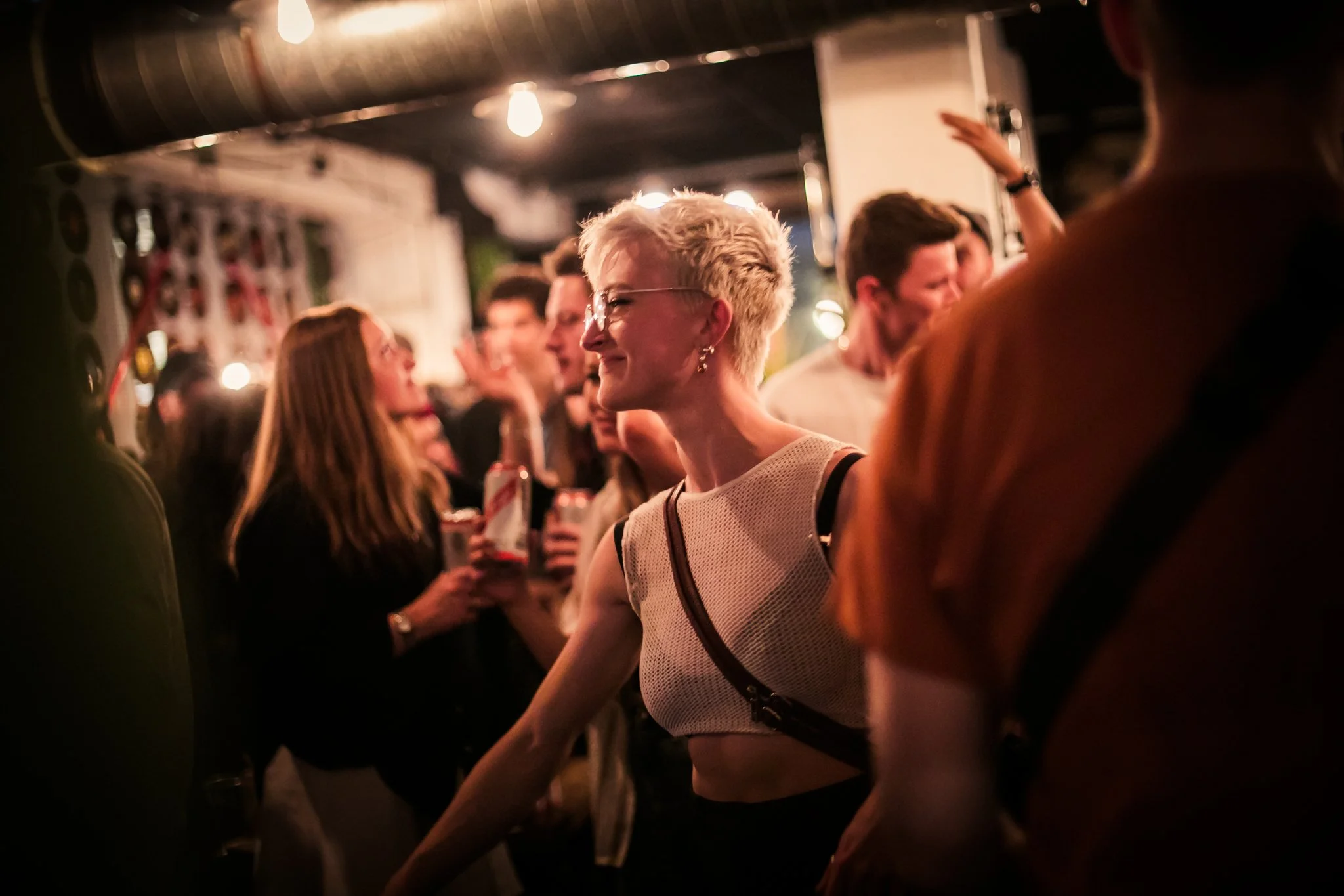 People socializing at a lively bar with dim lighting.