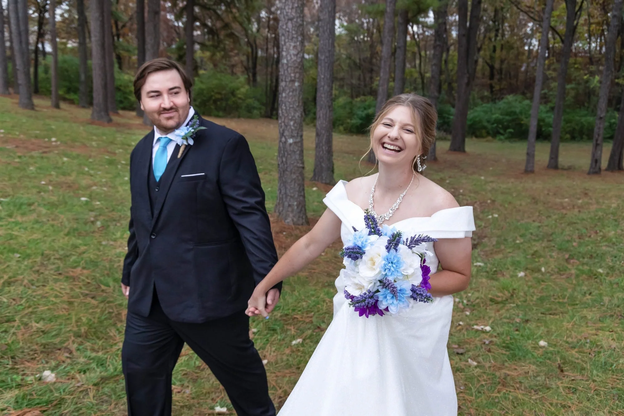 Amanda and her husband smiling and holding hands at their wedding in Konarcik Park for an About Me website feature.