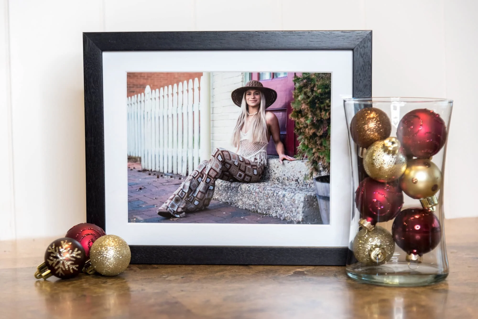 A professionally framed senior portrait print situated on a table showcasing custom wall art options.