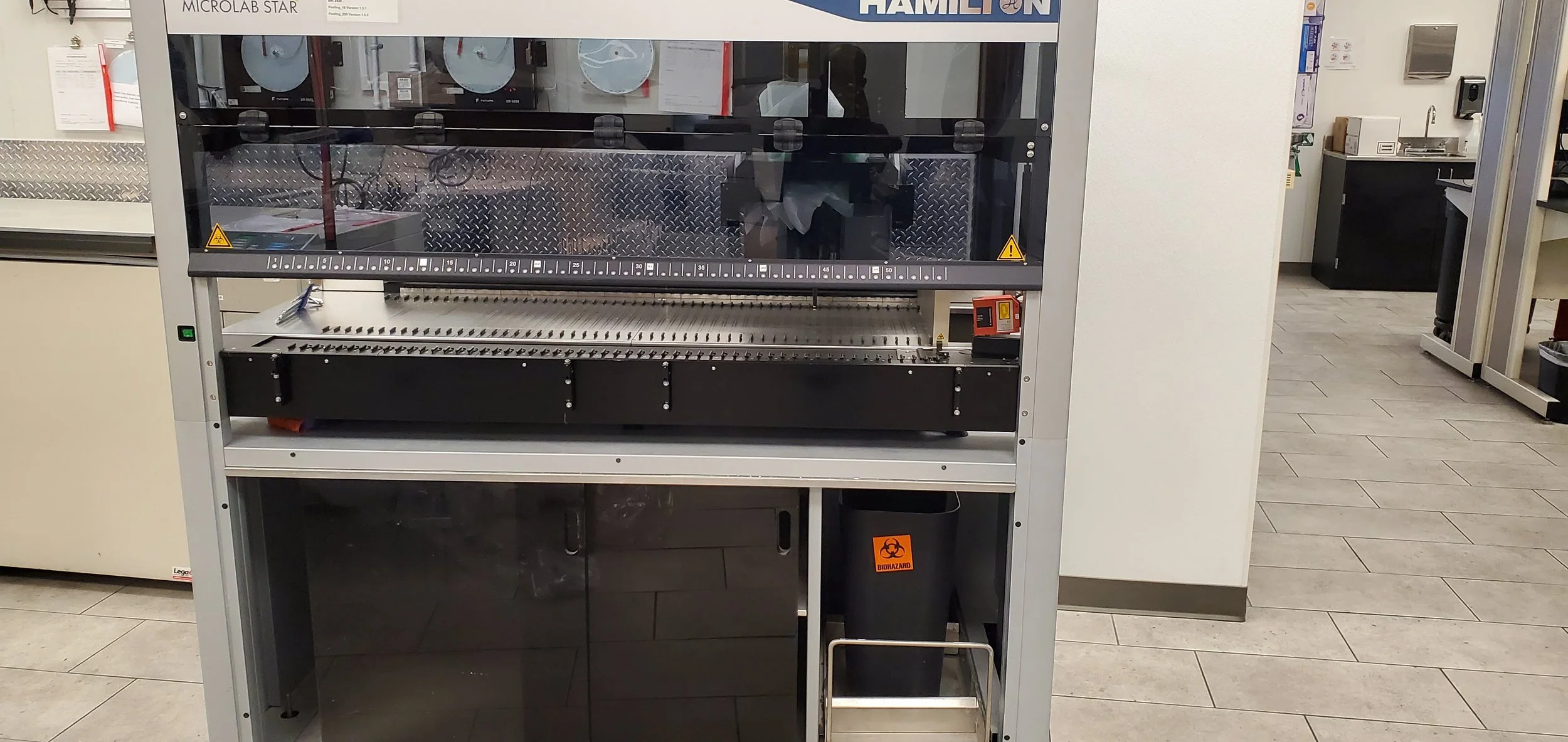 Installation  West Palm Beach Boca Raton, Delray Beach, Boynton Beach Laboratory fume hood or biosafety cabinet with warning signs and electronic controls located in a modern laboratory with tile flooring and other equipment visible in the background