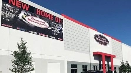 labor service service. Exterior of a Diamond MotorSports building with a sign advertising new motorsports and outdoor vehicle sales, featuring a digital billboard.