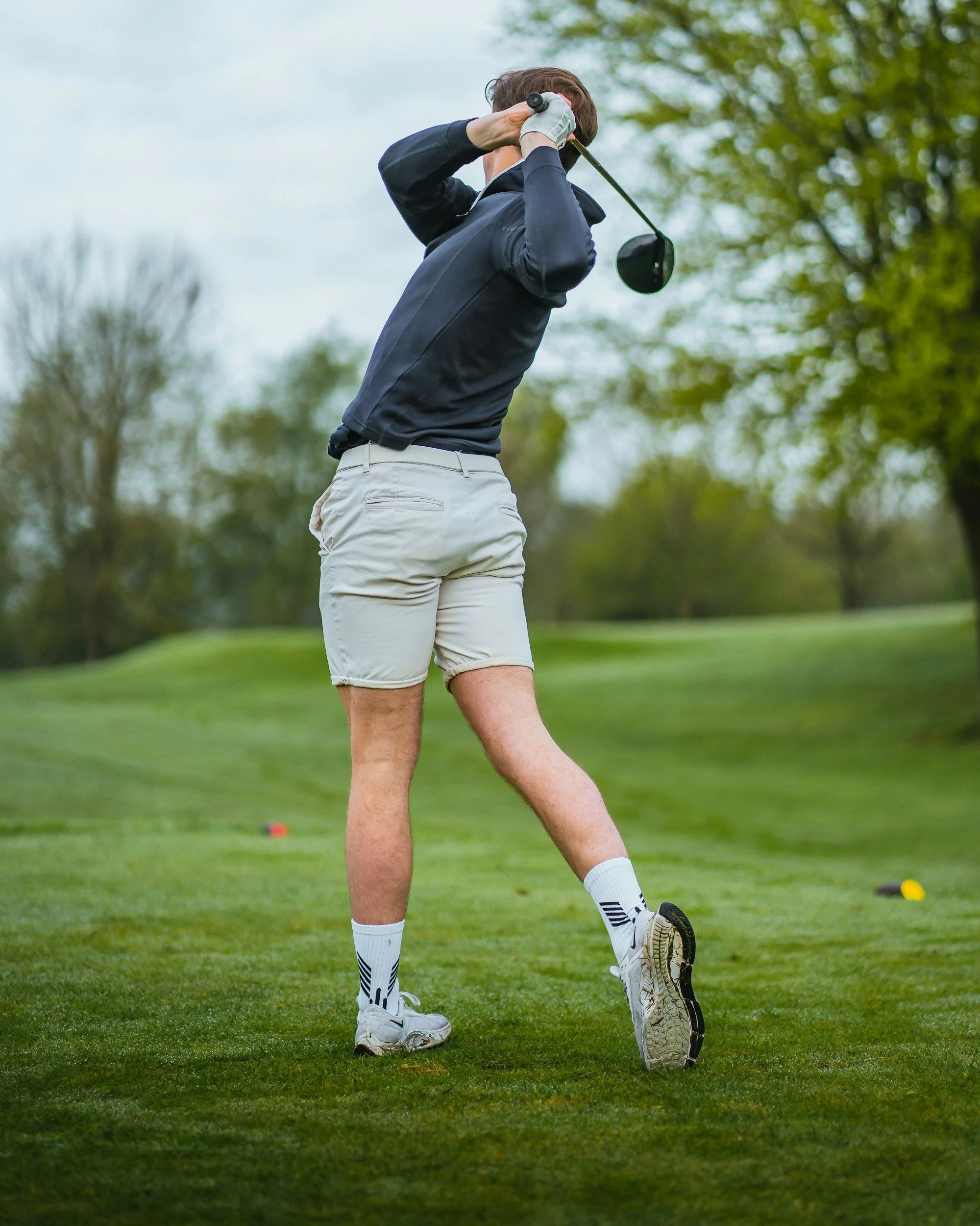 Golfer completing a swing that places repetitive demand on the hands, forearms, and elbows.