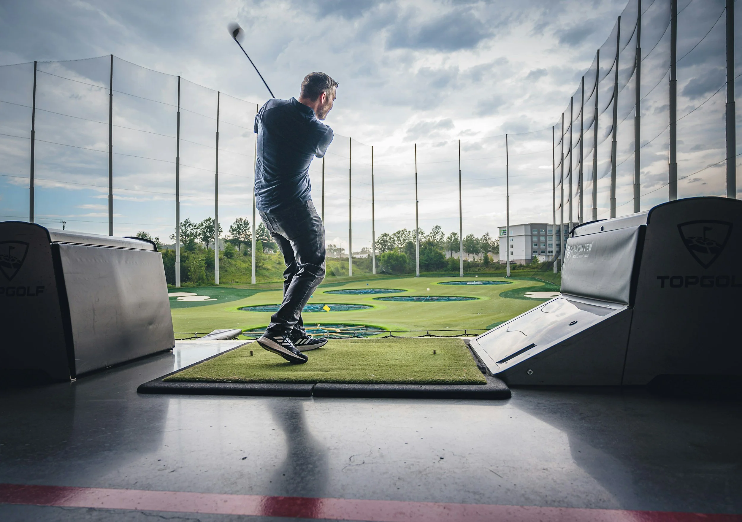 Golfer practicing his swing for massage for golfers with shoulder tension and low back pain
