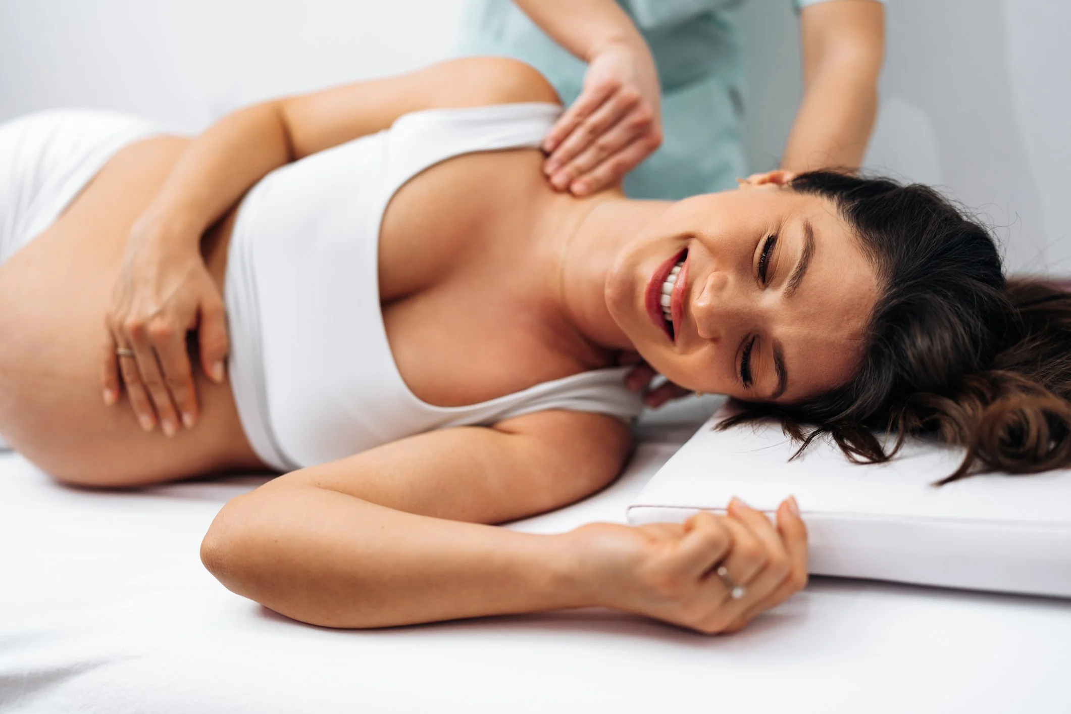 Pregnant woman resting on her side with pillows for support