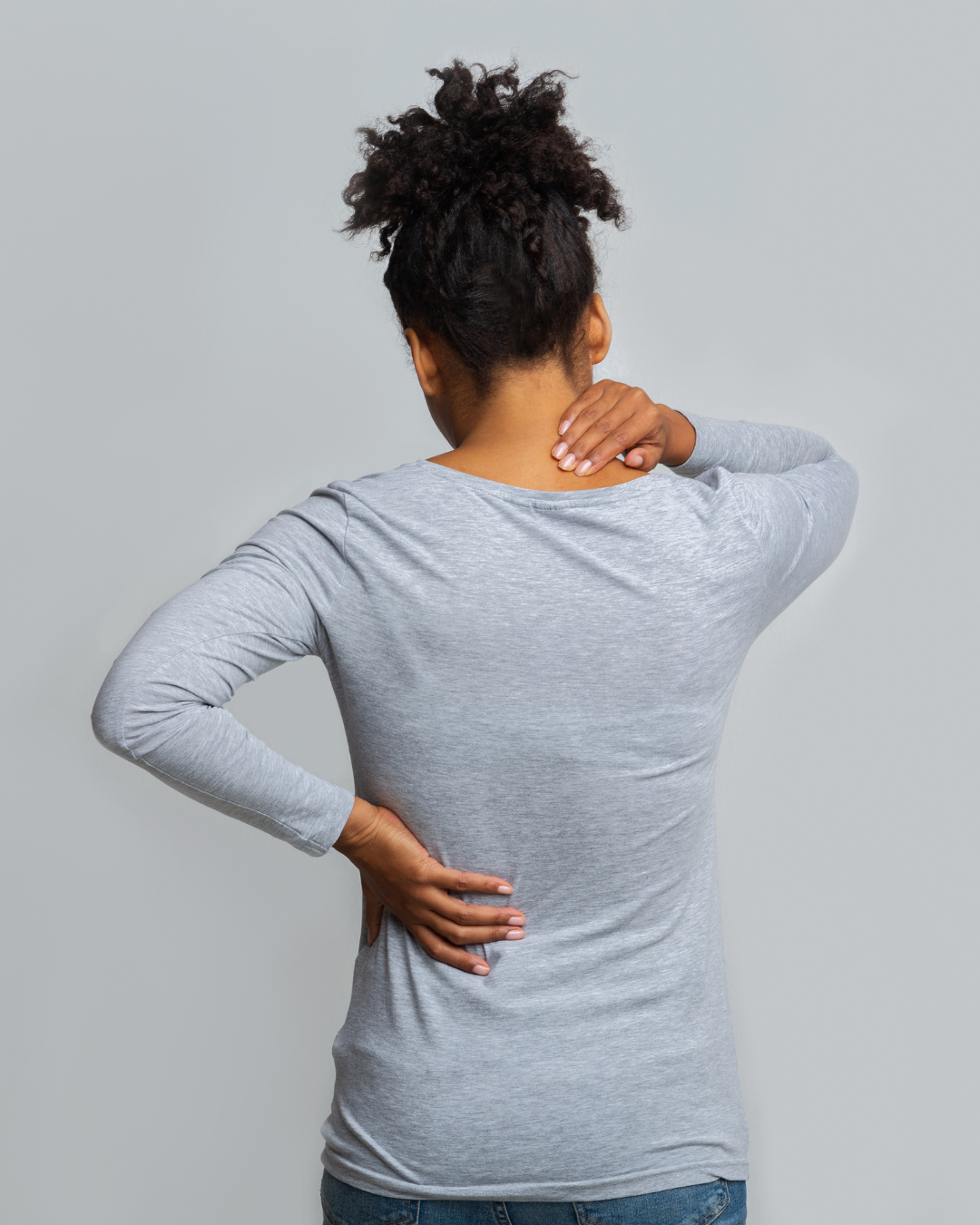 Person holding upper back and shoulder area showing rhomboid pain and upper back tension