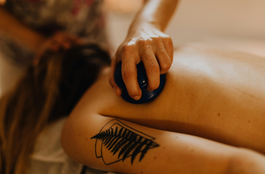 Therapist using a silicone cup during therapeutic cupping massage in Charlotte, NC.