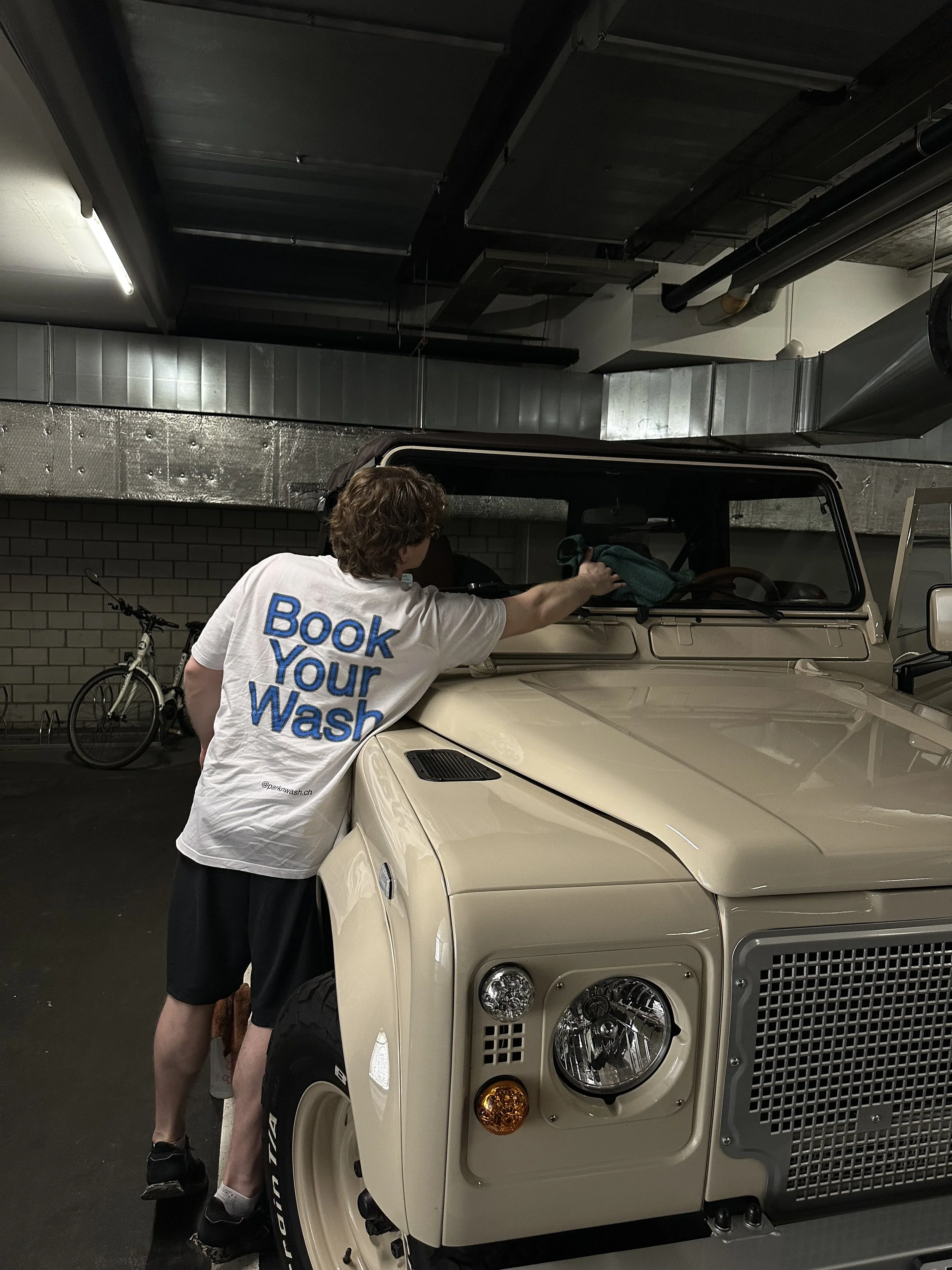 Park n Wash operator cleans windows of shiny off-roader