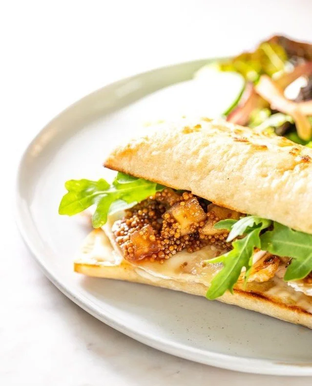 Introducing a new fall favorite: the Grilled Chicken Sandwich.
Served on toasted ciabatta with creamy brie, peppery arugula, apple mostarda, and aioli — finished with your choice of salt & pepper fries or a fresh salad.
Brunch just got