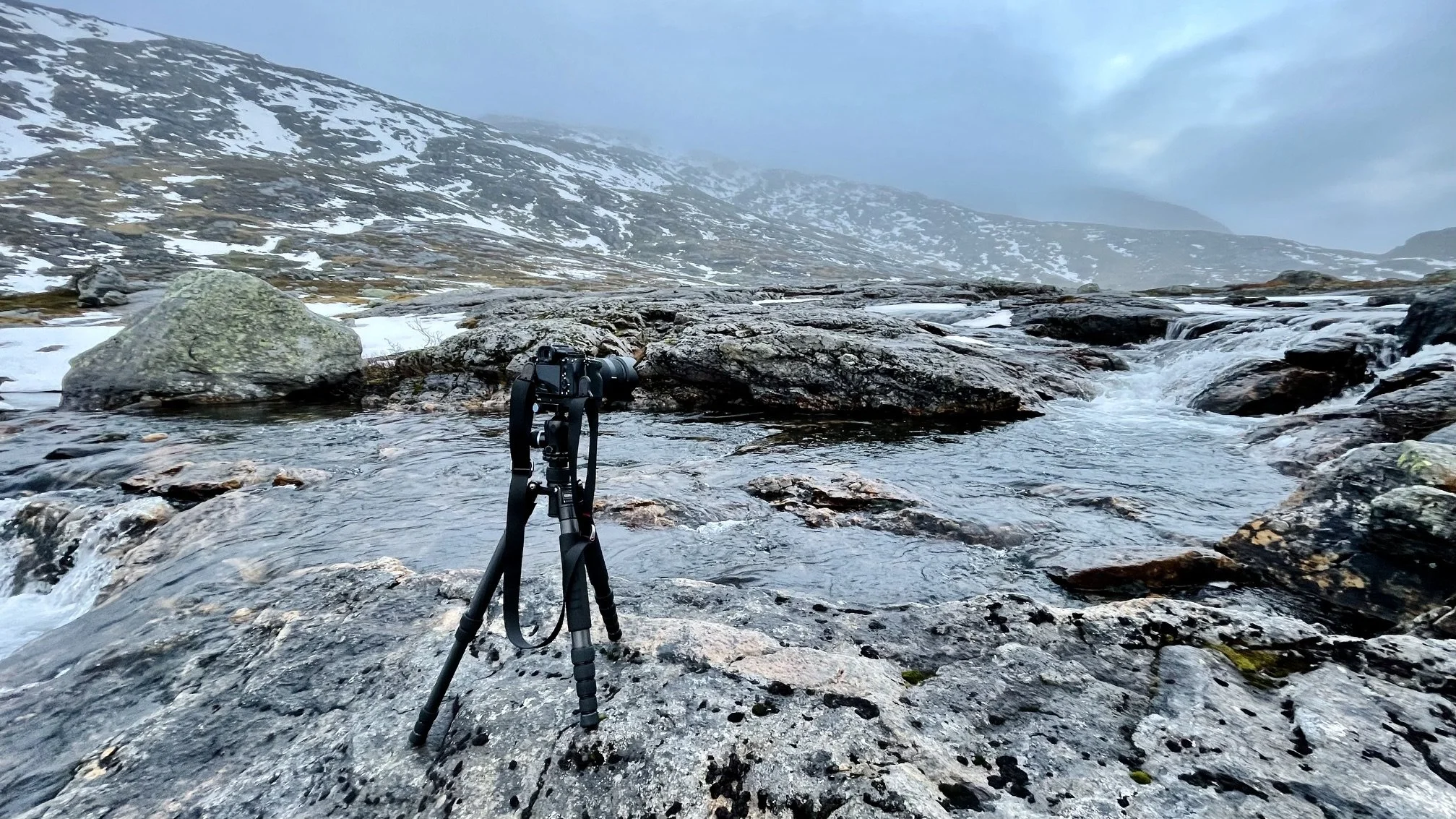 Camera on a tripod overlooking a small river in the mountains of Senja, Norway, in early November.