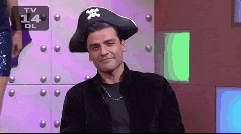 A looping gif of Oscar Isaac wearing a pirate hat and a hook on one hand as he salutes toward the screen.