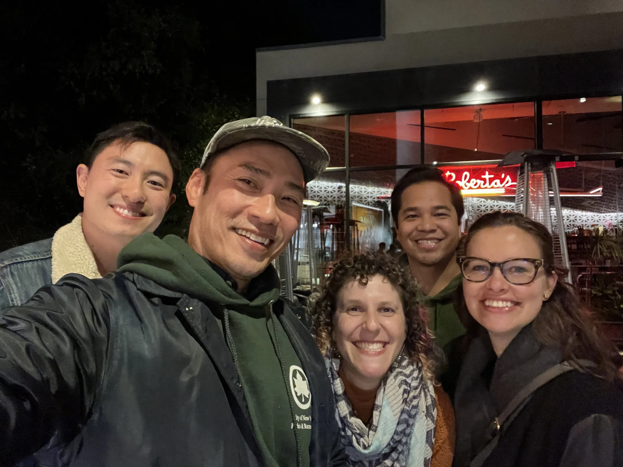 A selfie of 5 people smiling at the camera with me in the middle.