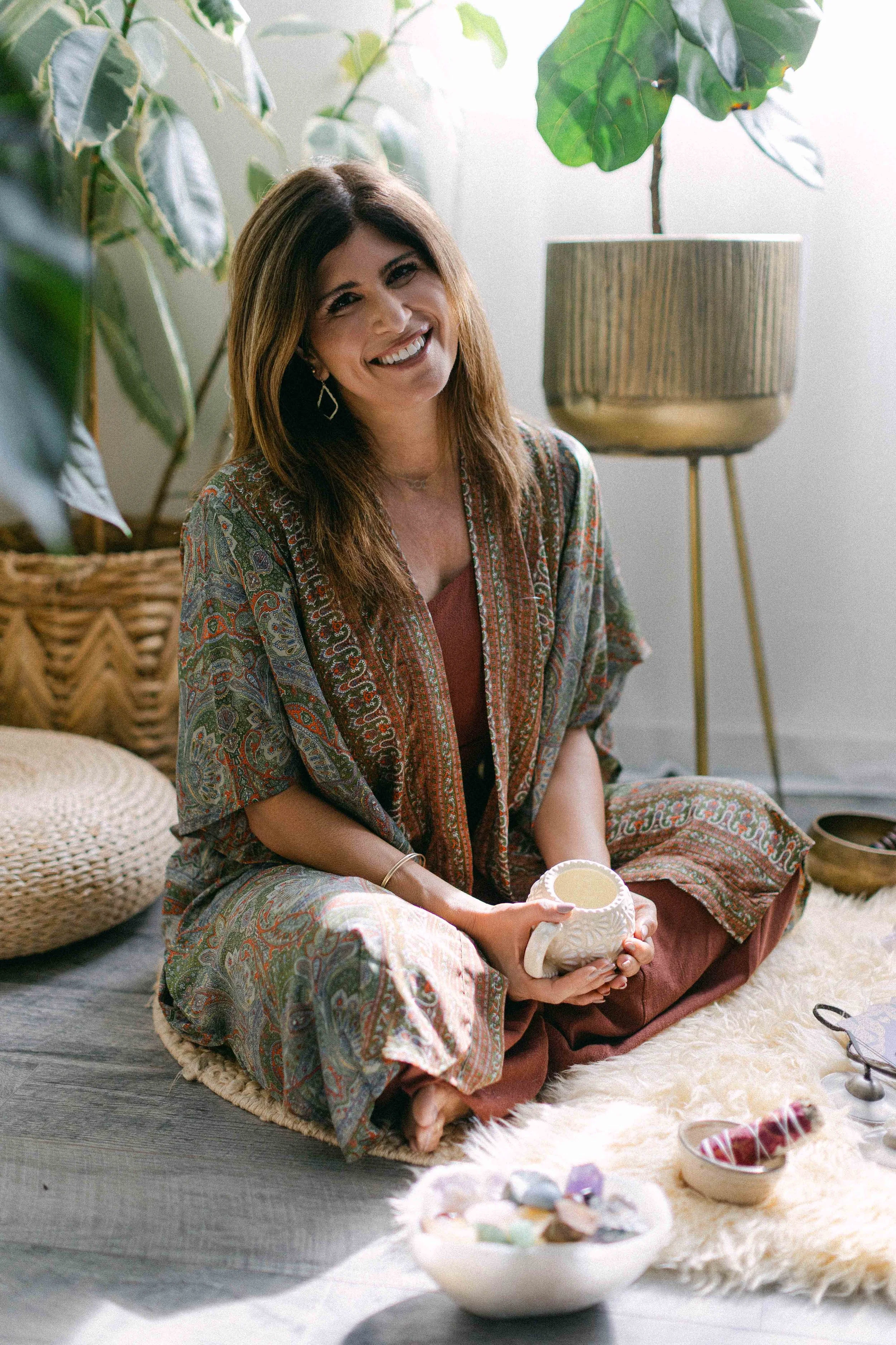 Jennifer smiling in a calming breathwork and Reiki space in Orange County, California.