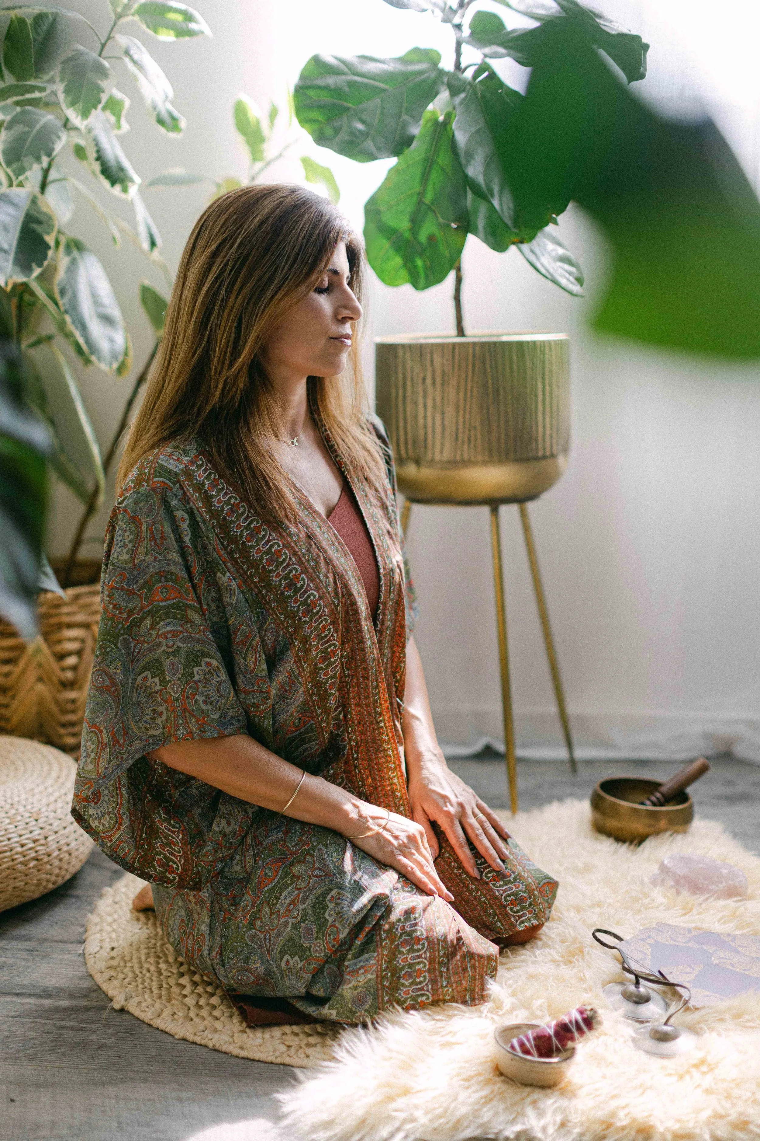 Jennifer kneeling in quiet meditation in her healing studio.