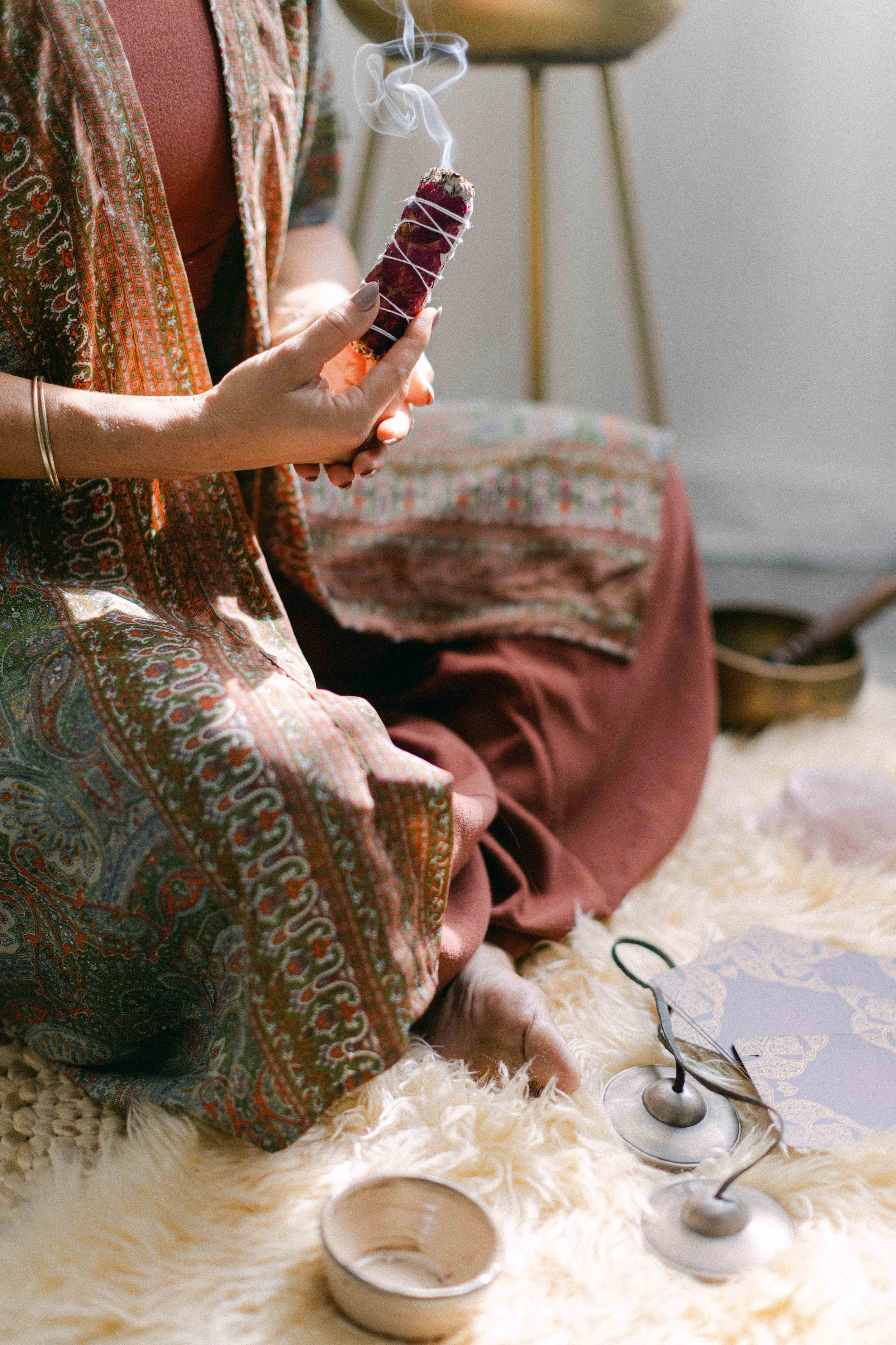 Woman smudging with sage in a ceremonial healing circle