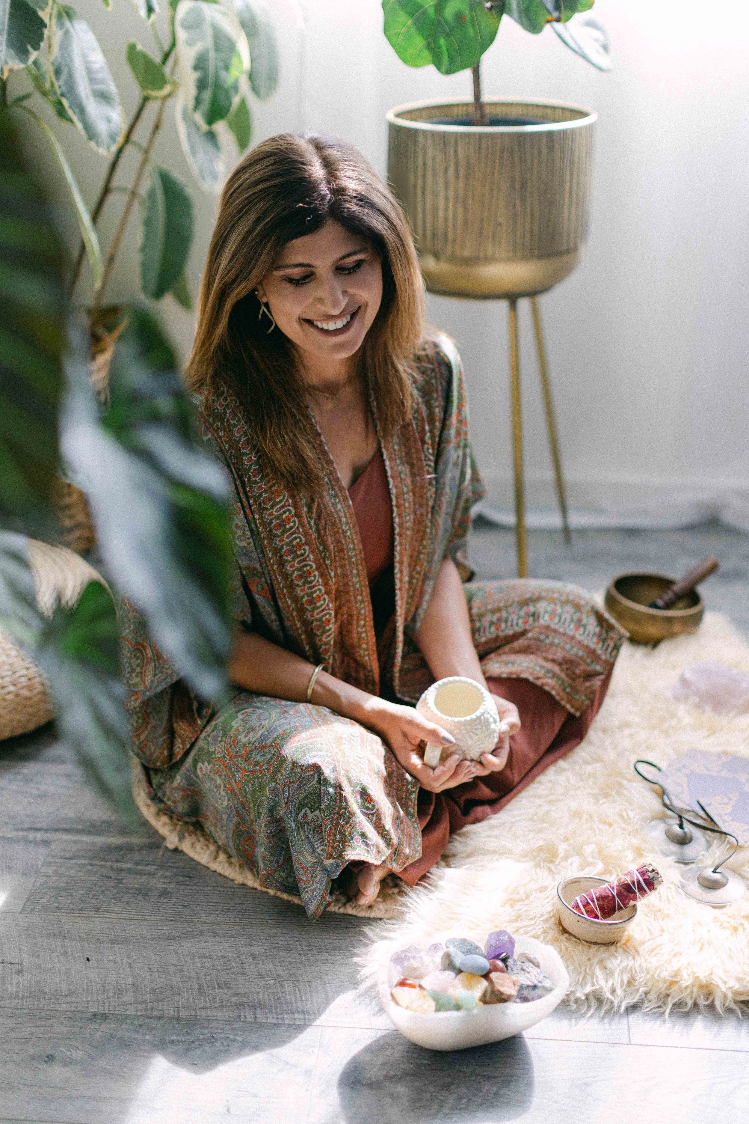 Jennifer seated with crystals and ritual tools in a calming breathwork and Reiki space in Orange County, California.