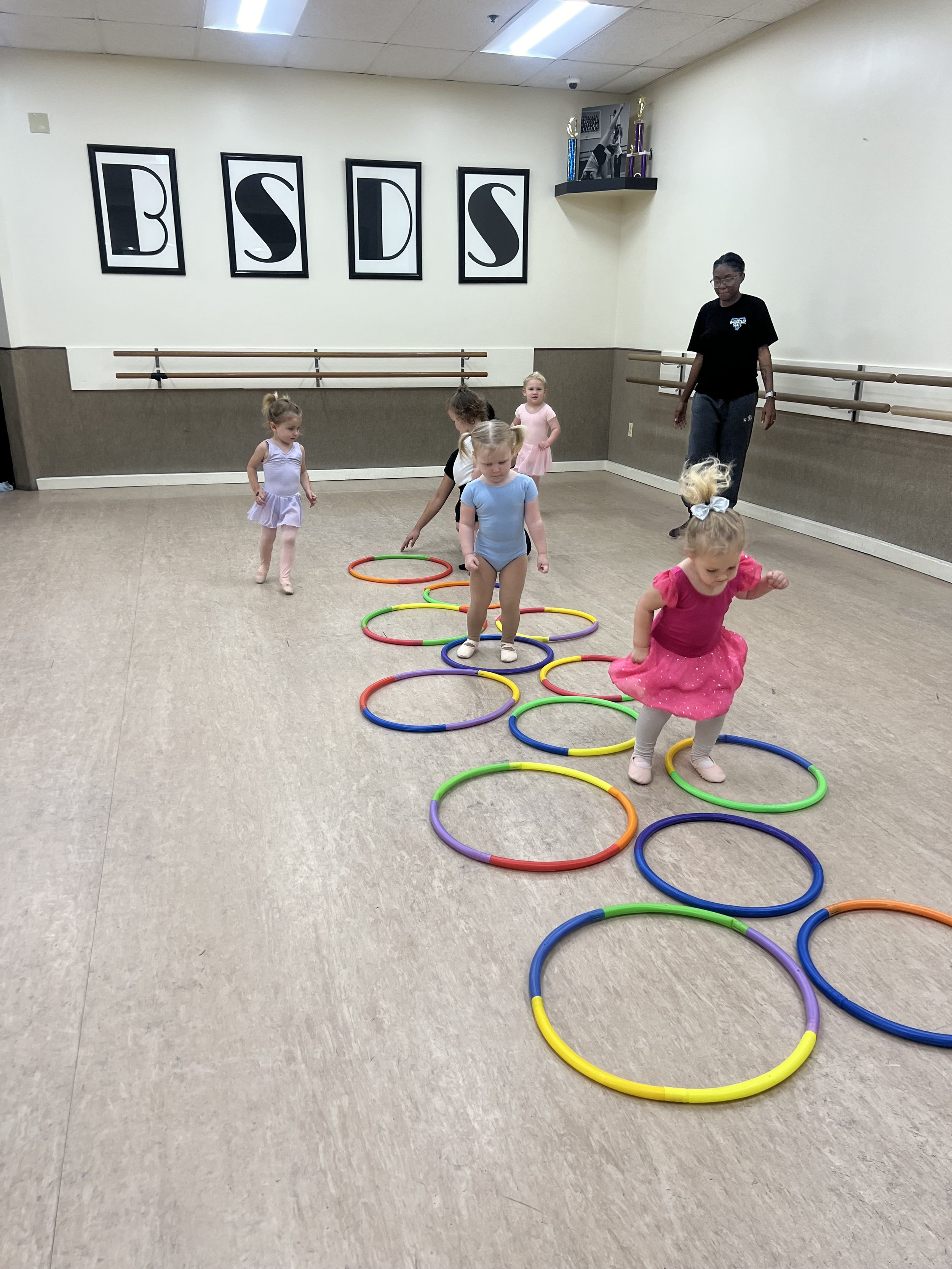 Rock-N-Tots dancers having fun playing hopscotch with hoops during dance class at Backstage Dance Studio in Columbia, MD.