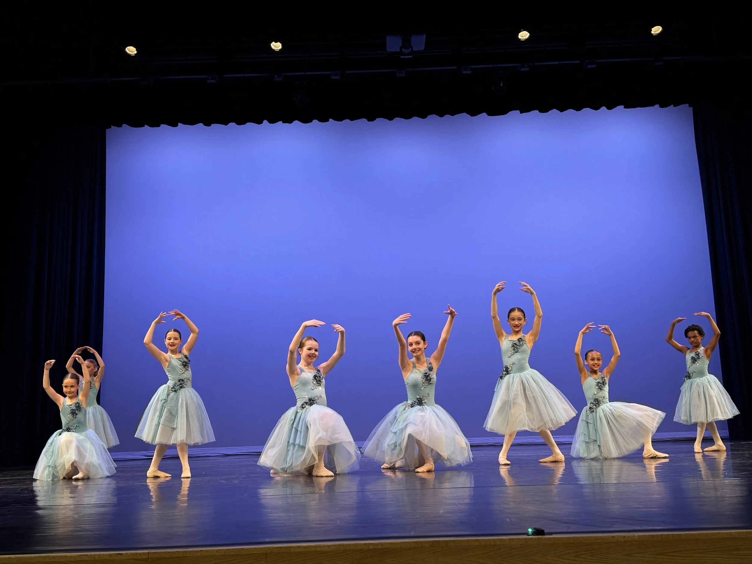 Teen dancers performing on stage during dress rehearsal for the Backstage Dance Studio annual recital.