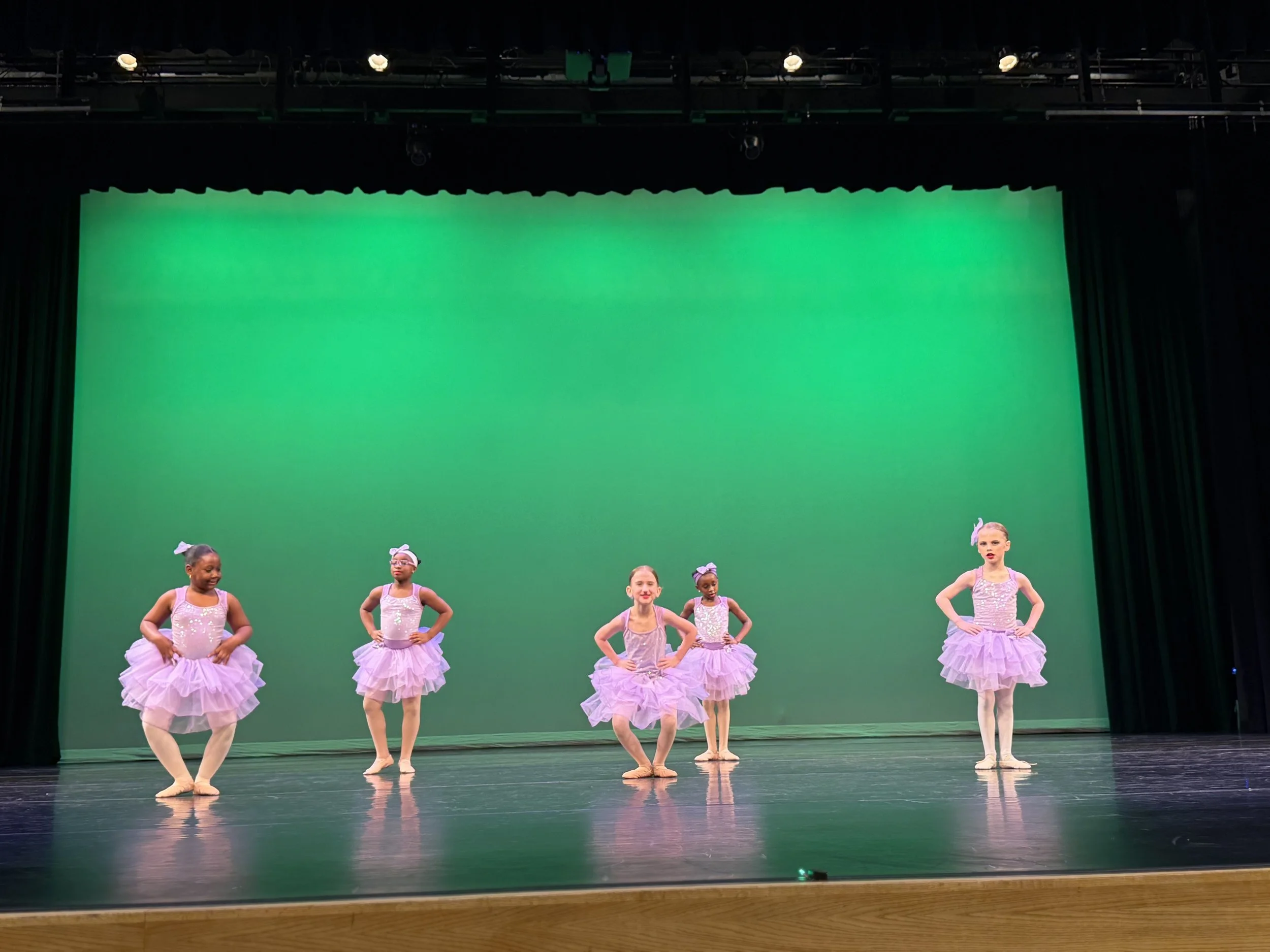 Young dancers performing on stage during dress rehearsal for the Backstage Dance Studio annual recital.