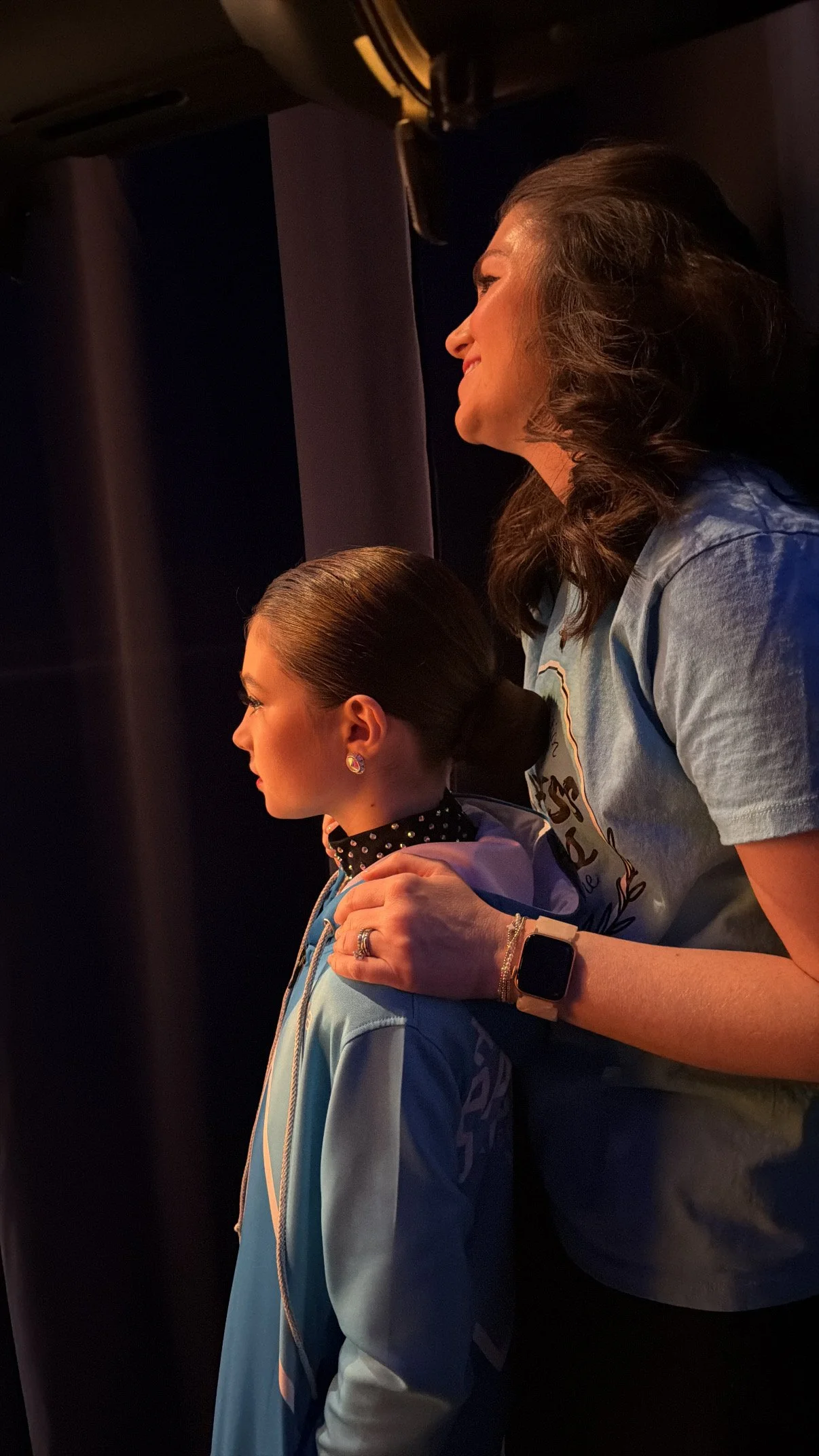 Mother and daughter watching dancers perform from the wings during the Backstage Dance Studio annual recital.
