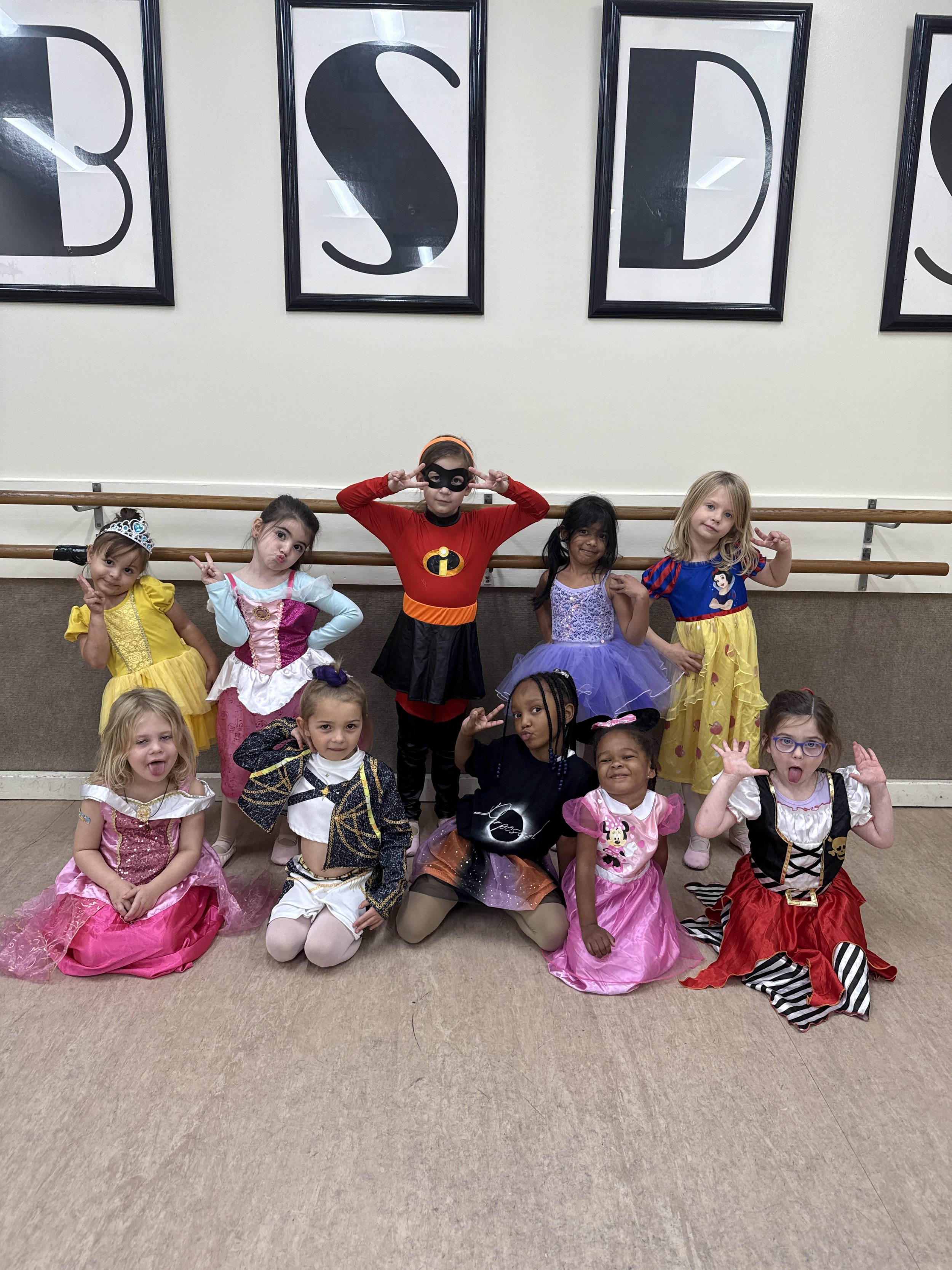 Backstage Dance Studio dancers celebrating Halloween together in costumes during a group photo.