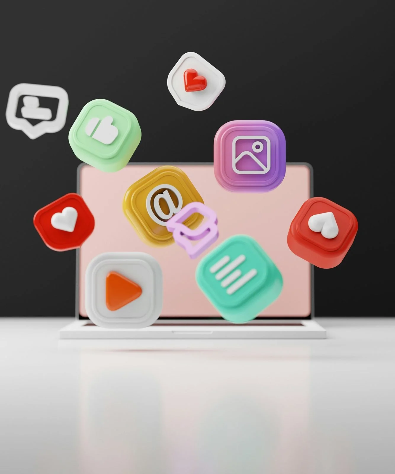 3D icons for video, images, email, likes and comments floating in front of a laptop