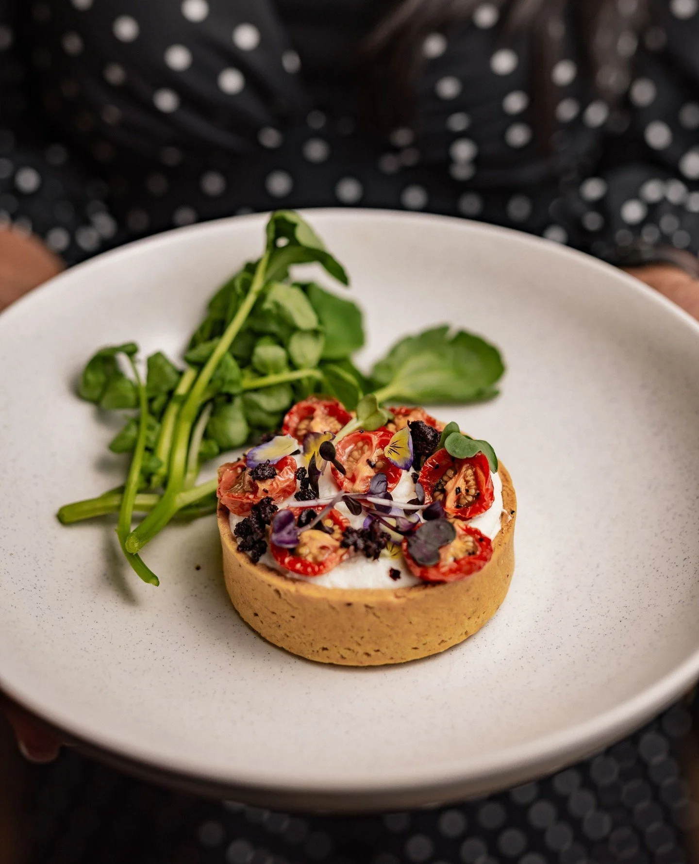 Whipped ch&egrave;vre tartelette with black olive, pea shoots, and vine-ripened cherry tomatoes - a perfectly balanced bite of fresh, creamy, and vibrant flavours 🍽️✨