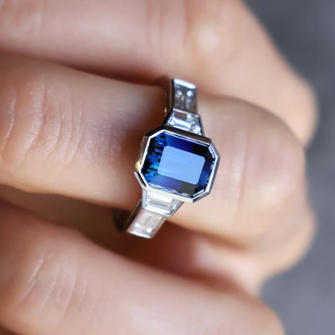 Emerald-cut blue sapphire and baguette diamond five stone ring bezel set in platinum
