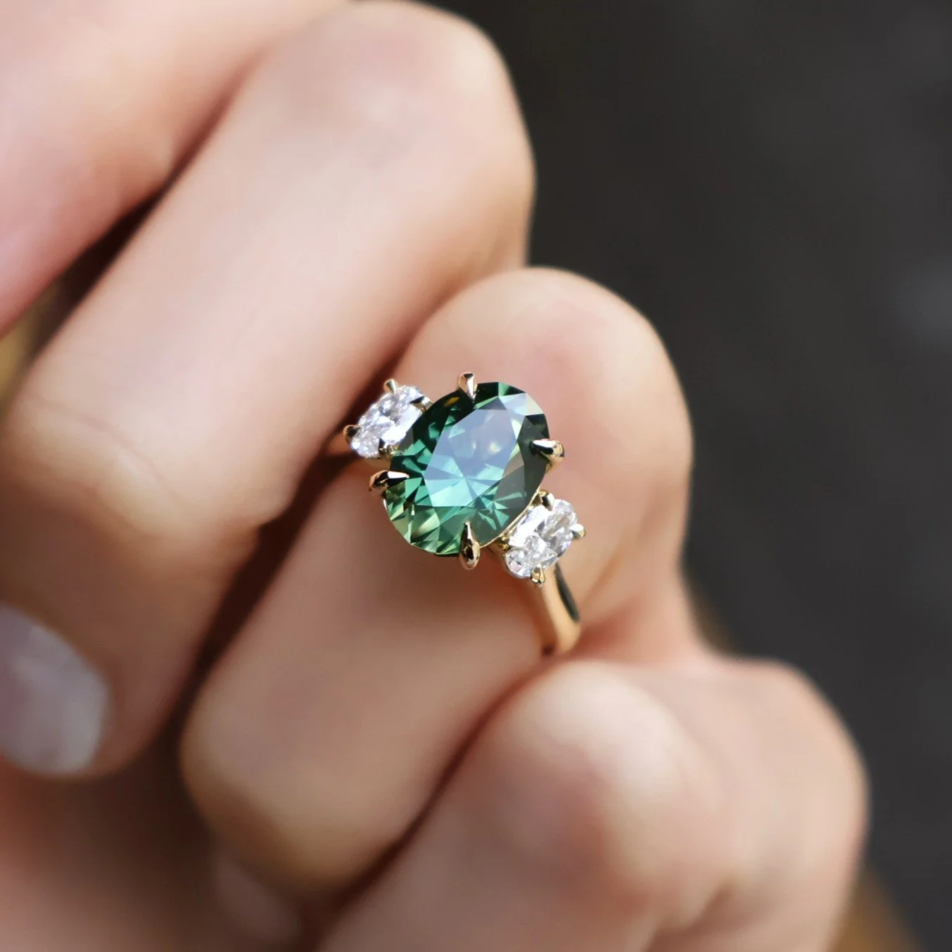 Oval green sapphire and oval diamond three stone ring on hand Issac.JPG