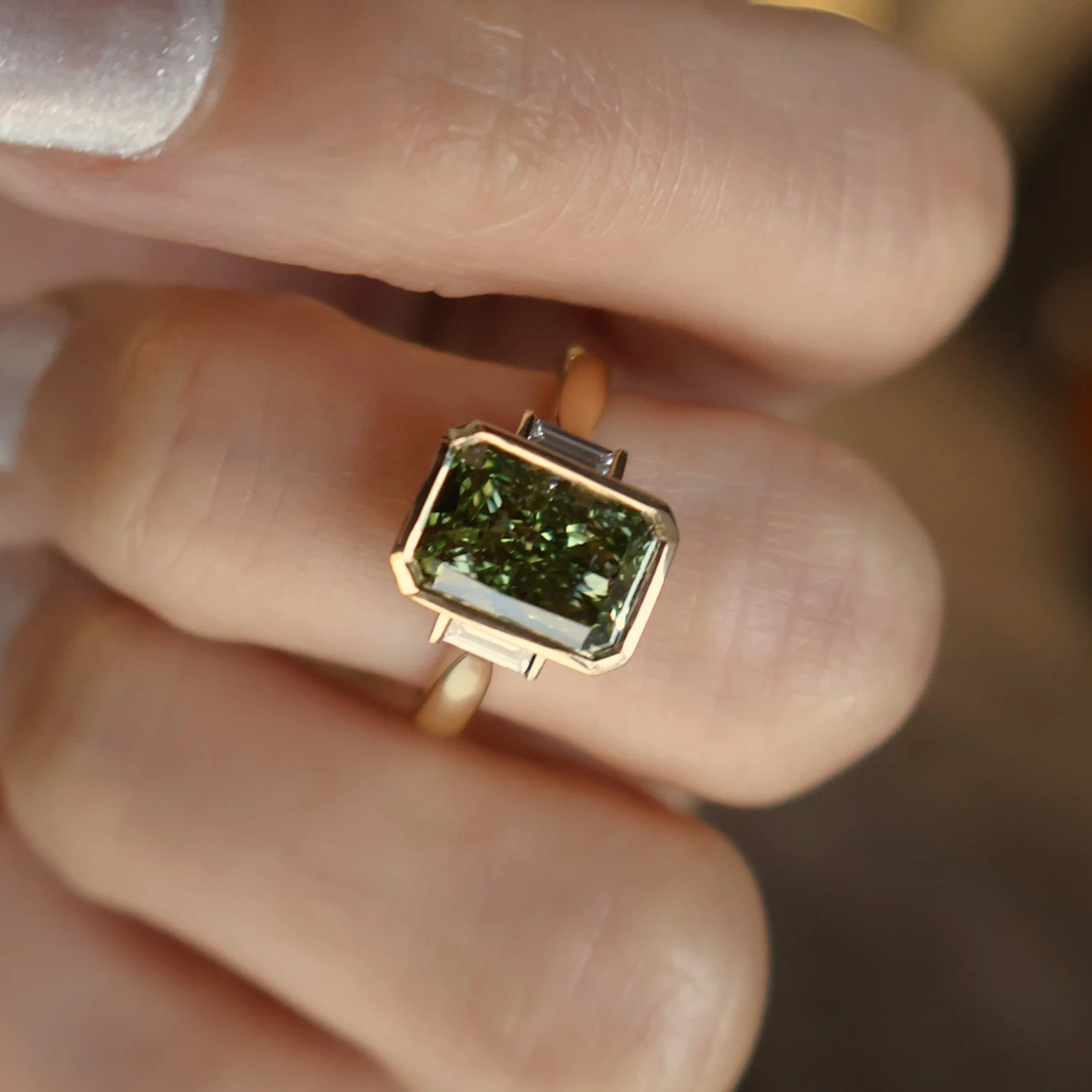 Green radiant lab diamond bezel baguette sides on hand.JPG
