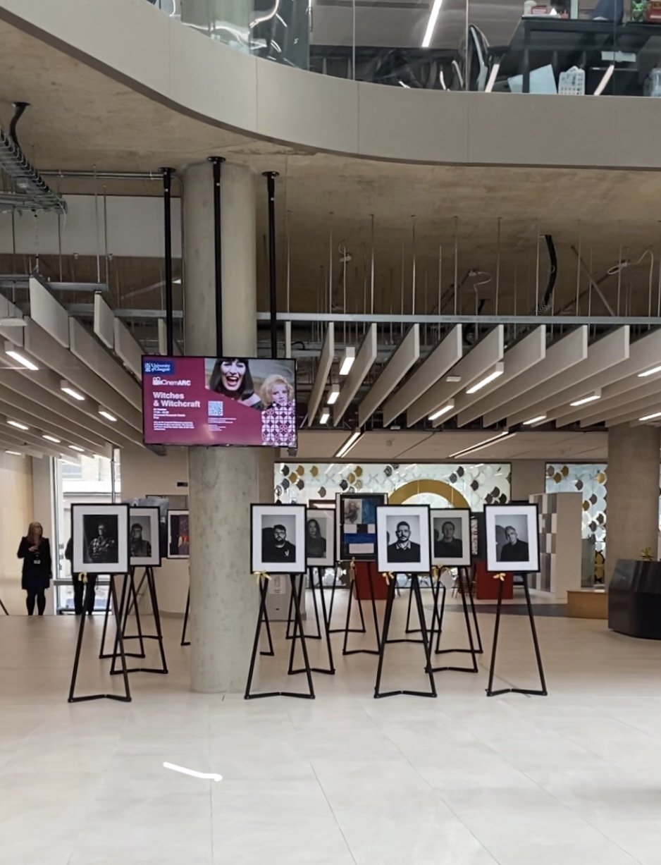 Framed Victorious Voices portraits displayed on easels inside a public venue. Learn about hosting an exhibition.