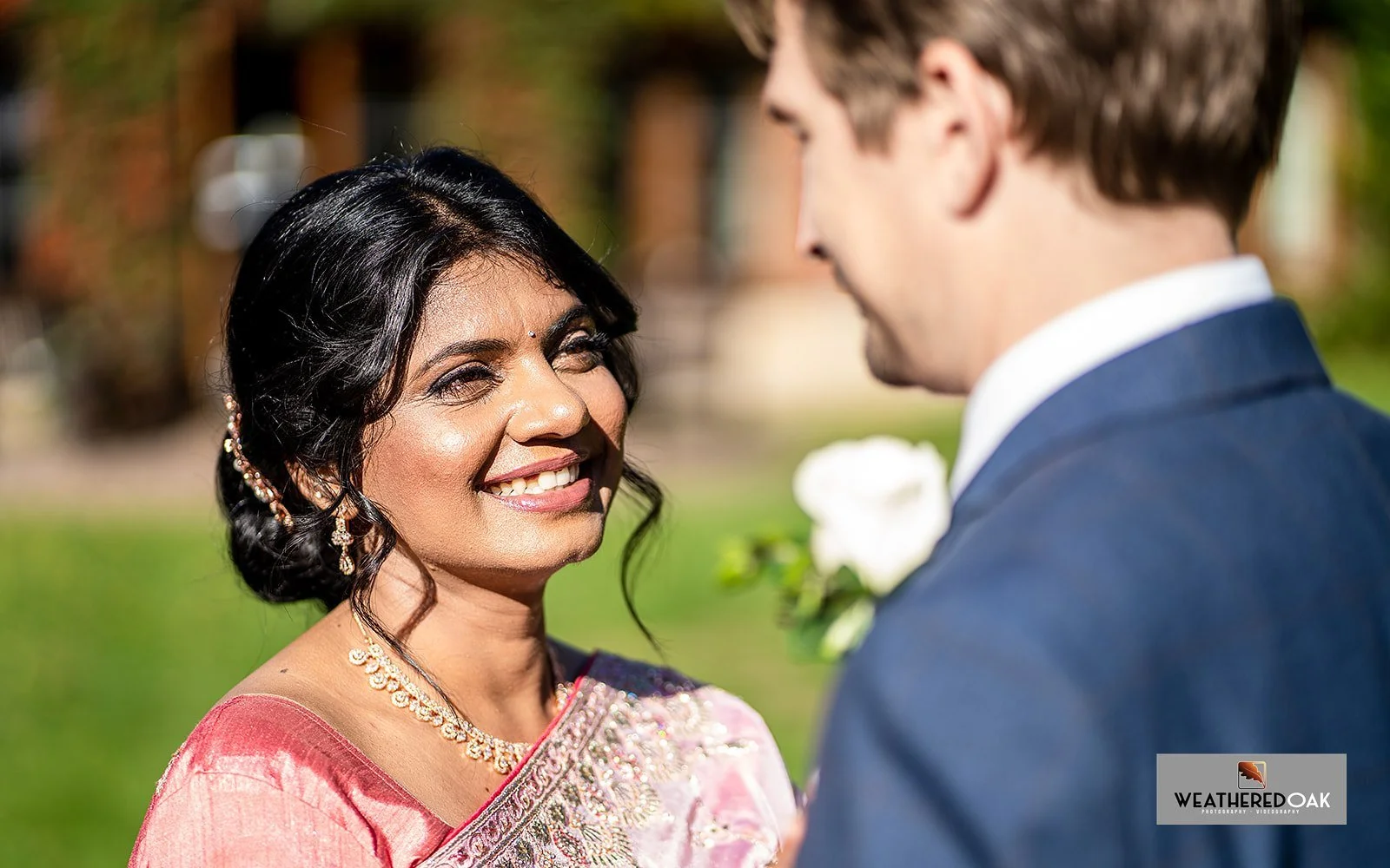 A woman in traditional attire smiling at a man in a blue suit.