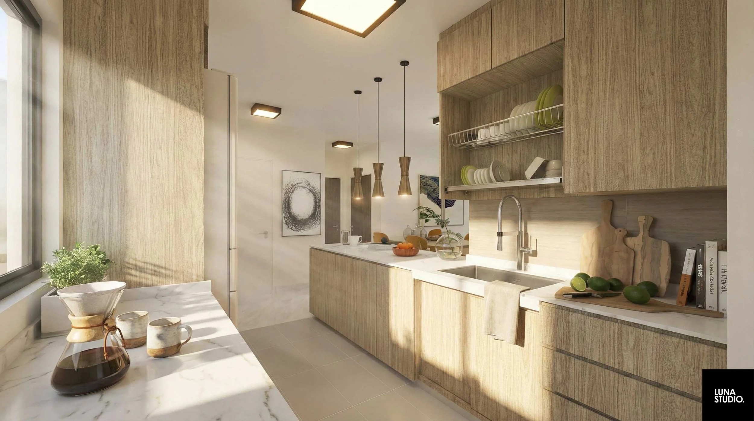 Modern kitchen with light wood cabinets, white countertop, and open shelving with dishes. Sunlight streams through a window onto a marble table with a plant and coffee set. Pendant lights hang above the kitchen island, and artwork decorates the white walls.